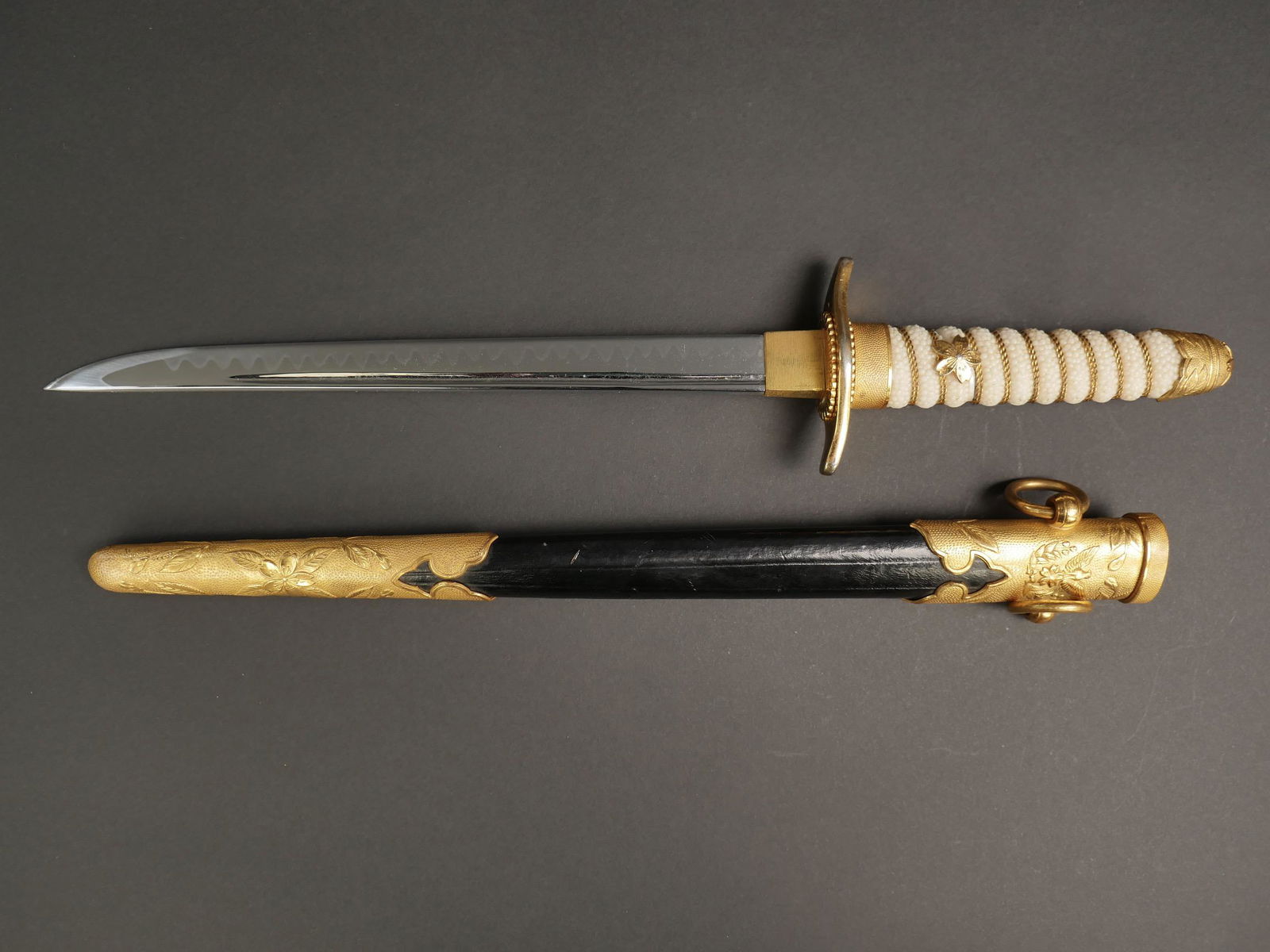 Dague Marine japonaise. Japanese Navy dagger.: Dague de la marine imperiale japonaise. Toutes les garnitures metalliques sont dorees. Pommeau decore d une fleur de cerisier. Poignee type galuchat, filigrane or et fleur de cerisier or. Fourreau en