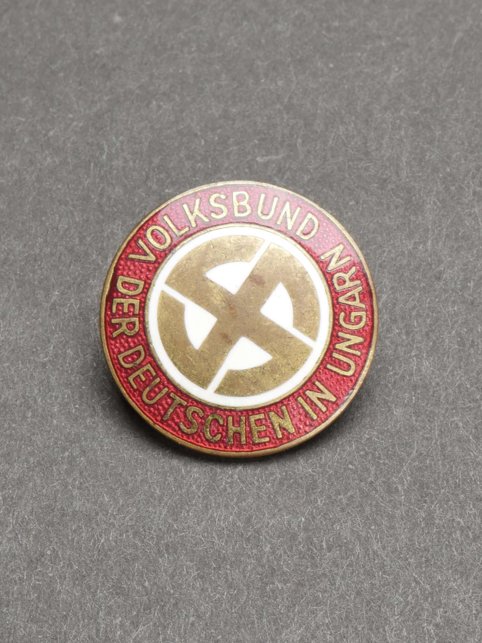 Insigne Volksbund Ungarn. Hungarian volksbund insignia.: Insigne Volksbund Ungarn. En metal emaille. Insigne national allemand dore. Marquages Der Deutschen Volksbund in Ungarn. Attache complete, sans marquages fabricant visibles. A noter une certaine usure