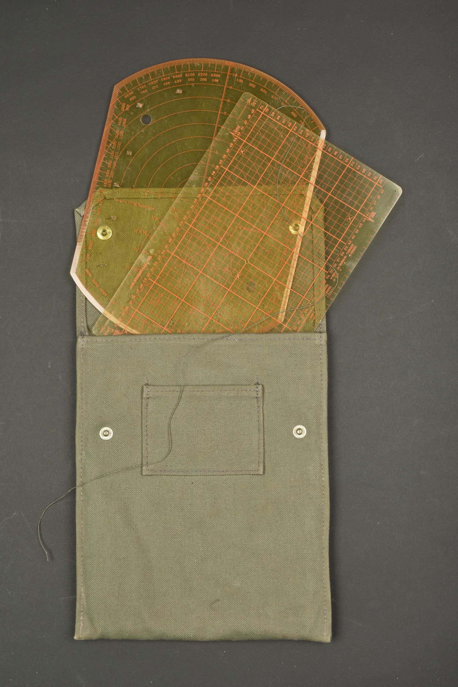 Pochette KW 27. KW 27 pouch.: Pochette KW 27. En forte toile Feldgrau, les deux boutons pression sont fonctionnels. Sans marquages visibles. Comprenant deux regles en bakelite jaune. Fabrication Gebr Widmann mbH 1934. Interieur do