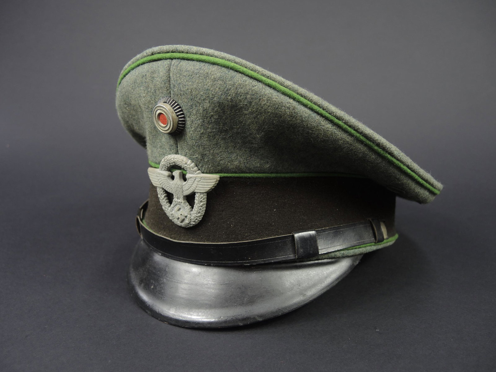 Casquette Polizei. German police cap.: Casquette de sous-officier Polizei. En drap gris/vert. Triple lisere vert typique de la Polizei. Bandeau en drap marron. Fausse jugulaire en cuir noir. Insignes metalliques. Les insignes n ont pas ete