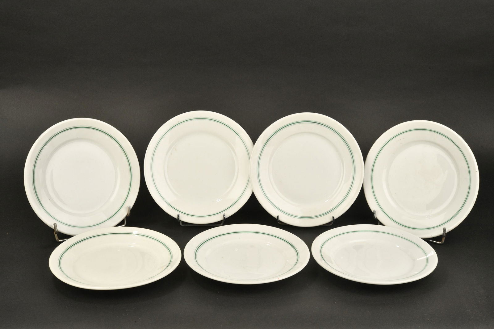 Petites assiettes Kriegsmarine. small plates Kriegsmarine.: Petites assiettes Kriegsmarine. Sept petites assiettes en porcelaine blanche, lisere vert. Modele pour les officiers. Fabrication KPM 1941, KPM 1942, . Diametre 16 cm. A noter une certaine usure et pa