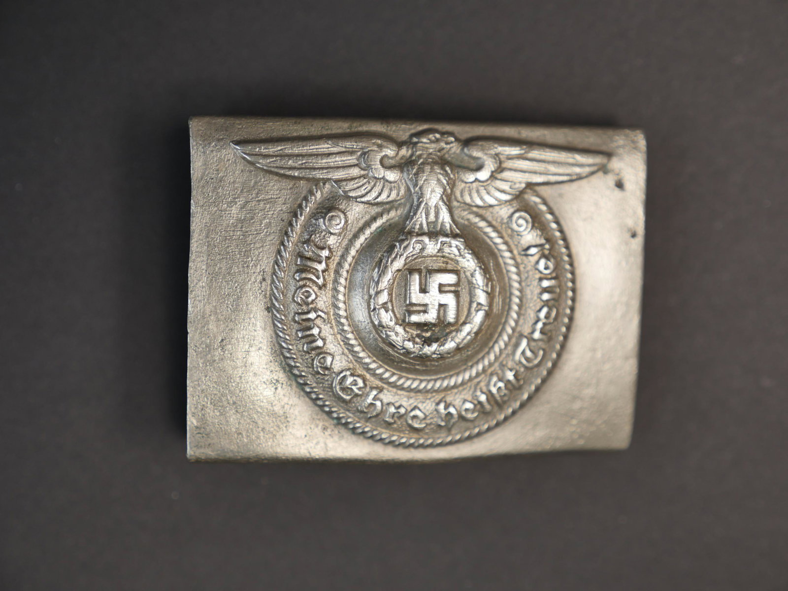 Boucle SS. SS Belt buckle.: Relique de boucle de ceinturon SS. En metal, modele precoce, couleur argent posterieure, nombreux manques et marques d oxydation, ardillon absent. Marquages RZM SS. Selon les informations du vendeur c