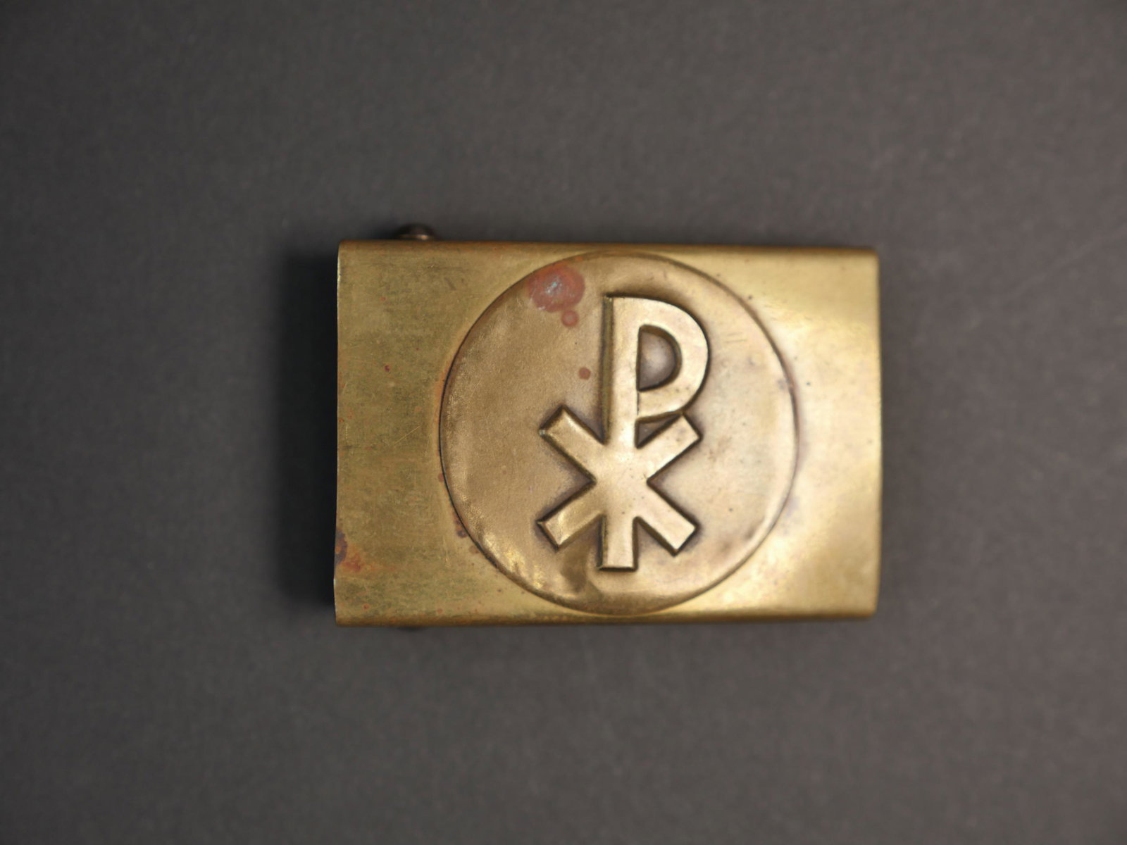 Boucle de ceinturon. German belt buckle.: Boucle de ceinturon Katholische Jugendgemeinschaft Jungm anner Bund. En laiton. Presentant quelques marques d oxydation et bosses. Fabrication en deux parties. A noter une certaine usure et patine de 