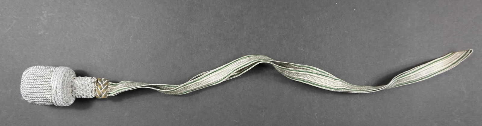 Dragonne pour dague forestier. Lanyard for woodworking dagger.: Dragonne pour couteau ou dague des cadres des chasses et des forets. Gland en fil aluminium. Cordon de passementerie en fil aluminium argente et lisere vert. Longueur 45 cm. A noter une legere usure e