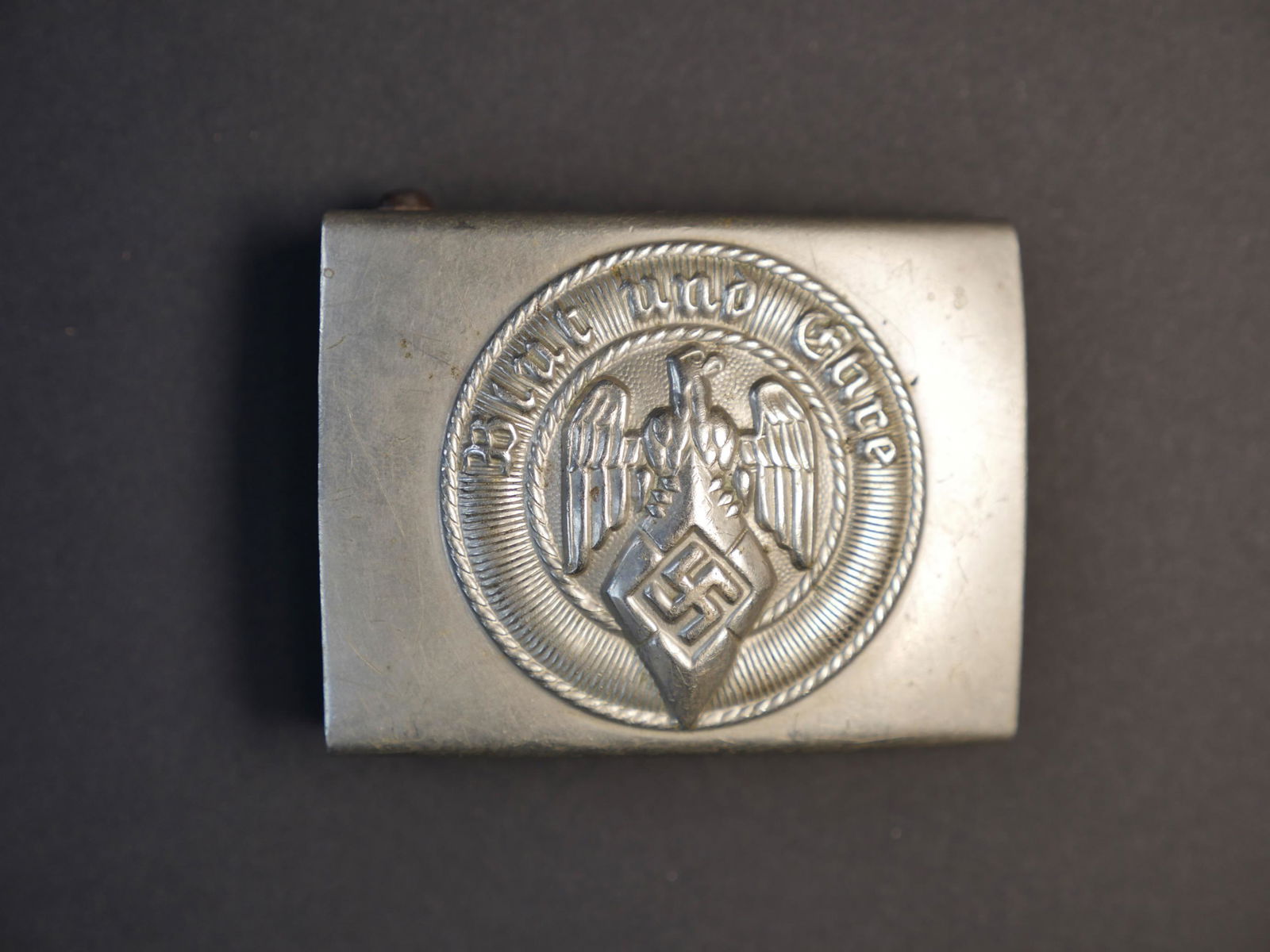 Boucle HJ. Hitlerjugend belt buckle.: Boucle de ceinturon troupe Hitlerjugend. En metal. Fabrication RZM MA 45. Etiquette RZM numero 103543. A noter une certaine usure et patine de la piece. Etat II+. Hitlerjugend troop belt buckle. Made