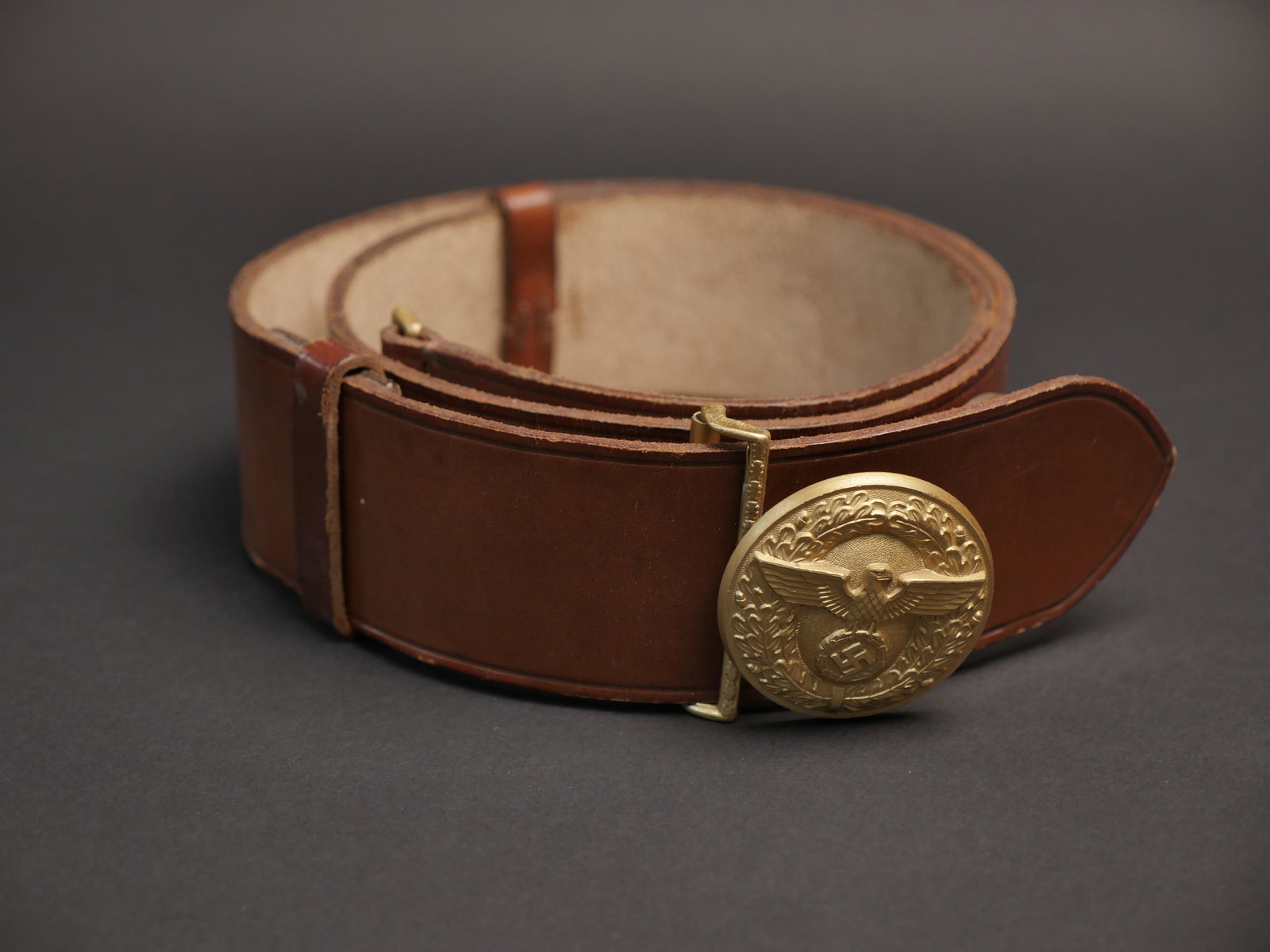 Ceinturon PL. Politischer Leiter belt.: Ceinturon de Politischer Leiter. En cuir marron. Marquages Croupon RZM L2/600/42. Les deux passants en cuir sont presents, un passant dispose d un tampon RZM. Taille 110, bouclerie en metal dore. Bouc