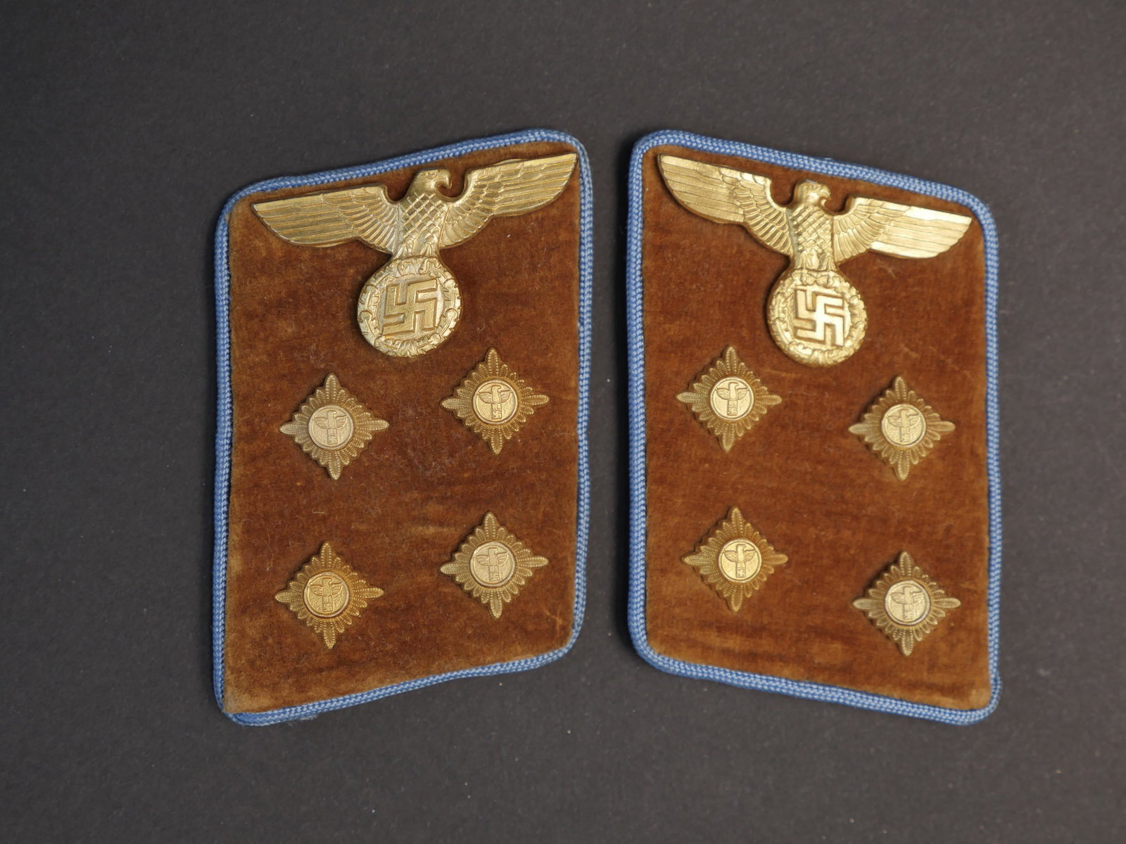 Patte de col PL. Politischer Leiter collar tabs.: Paire de patte de col Politischer Leiter. Paire homogene en velous marron, lisere bleu ciel faisant le tour des pattes de col. Quatre clous de grade dores et un aigle dore, correspondant au grade de G