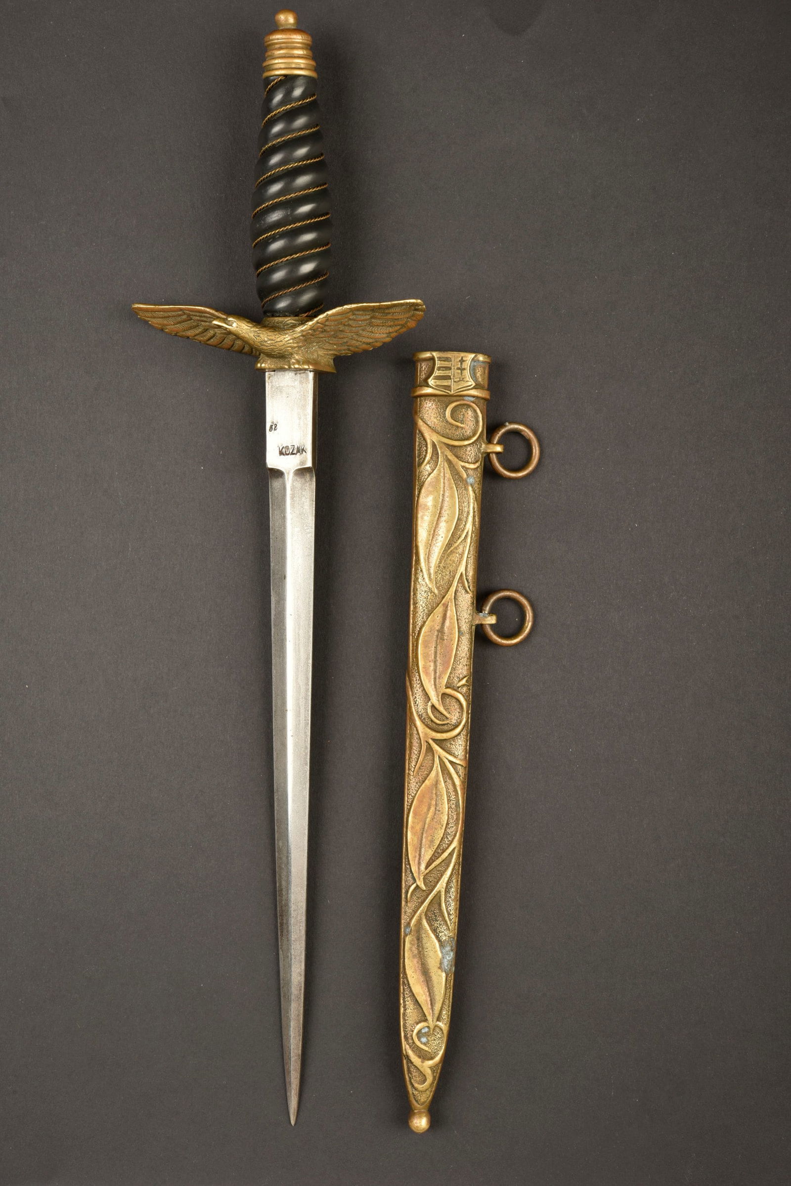 Dague de aviation croate. Croatian aviation dagger.: Dague de l'aviation croate. Pommeau en metal complet. Poignee de couleur noir, filigrane or present. Garde sous forme d'aigle en vol avec drapeau croate. Fourreau en metal a decors floraux. Bouton pou