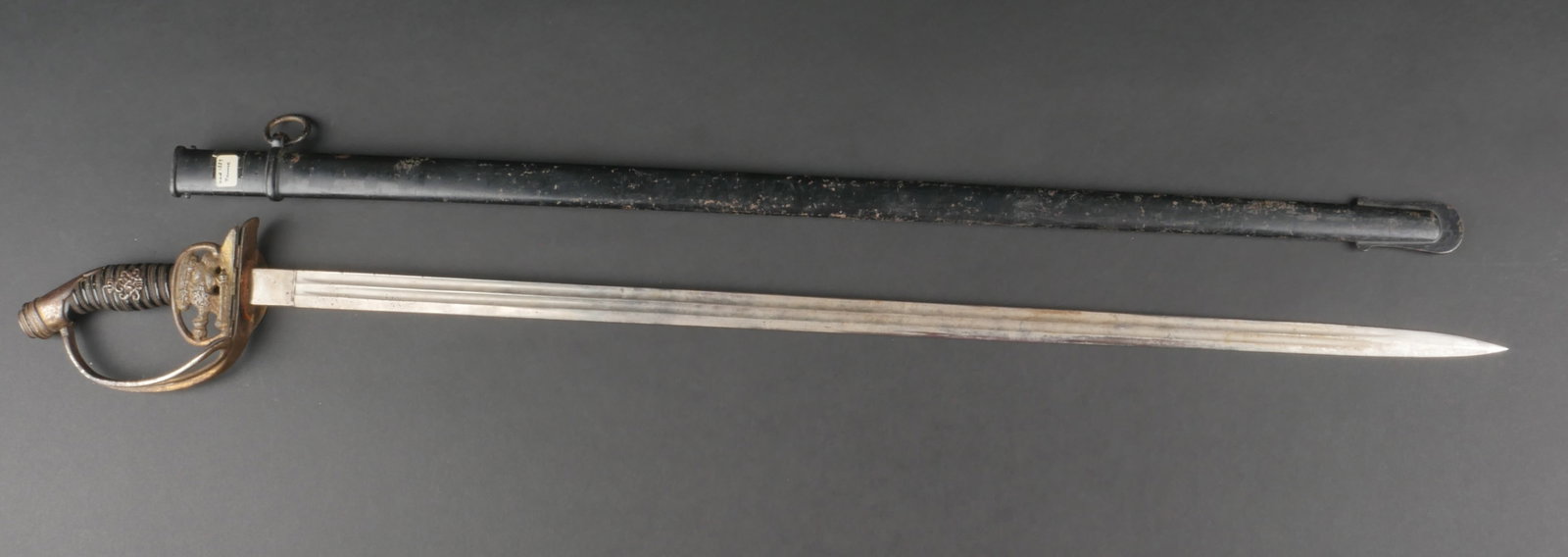 Sabre prussien. Prussian sword.: Sabre prussien. Garnitures en metal, la dorure est presente a 30%. Poignee en bois noir disposant d'un monogramme sous couronne. Filigranne present. Garde a clapet, fonctionnelle, decoree d'un aigle p
