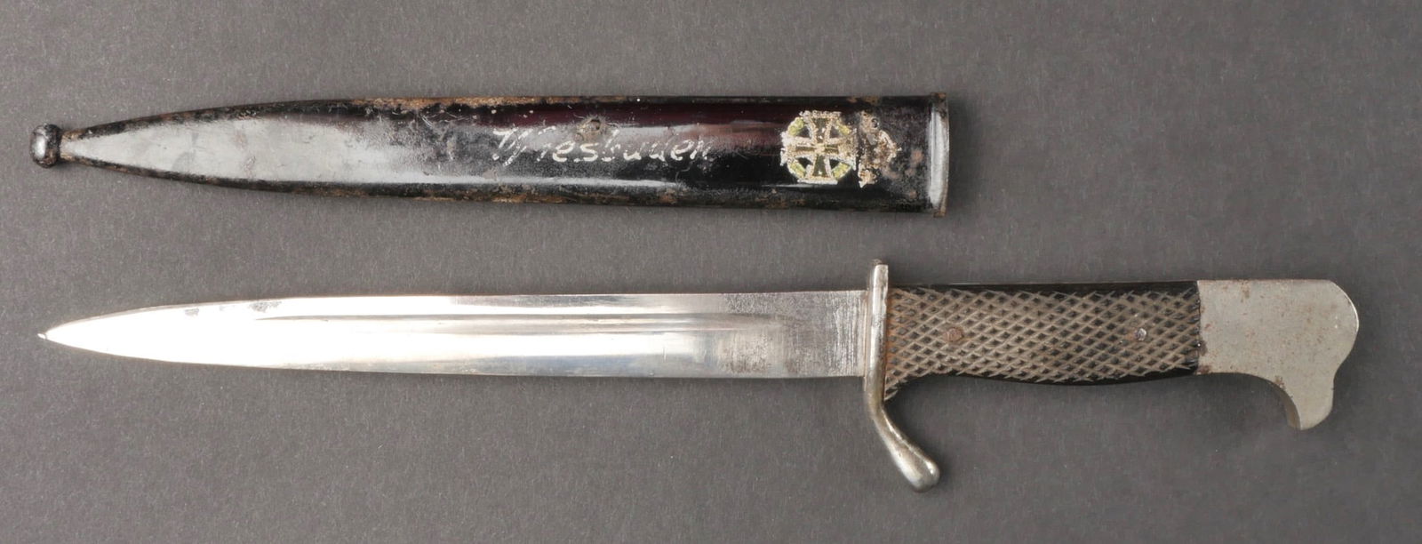 Couteau commemoratif. Memorial knife.: Couteau patriotique allemand. Garnitures en metal, plaquettes en bakelite maintenues par deux rivets. Belle lame presentant quelques taches et marques d'oxydation. Fourreau en metal, couleur noire a 7