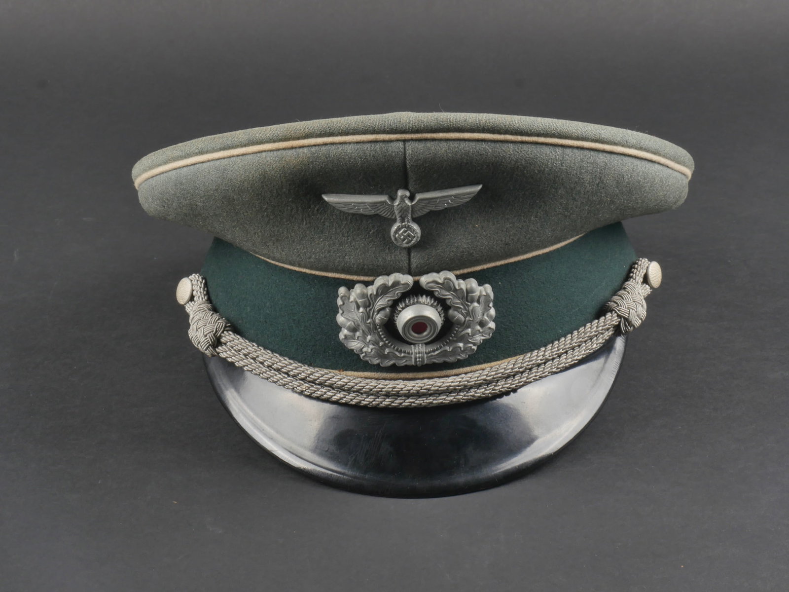 Casquette officier infanterie. German officer cap.: Casquette d'officier d'infanterie. En gabardine Feldgrau, triple lisere blanc de l'infanterie. Les insignes sont metalliques. Les insignes n'ont pas ete demontes afin de verifier les pattes. Fausse ju