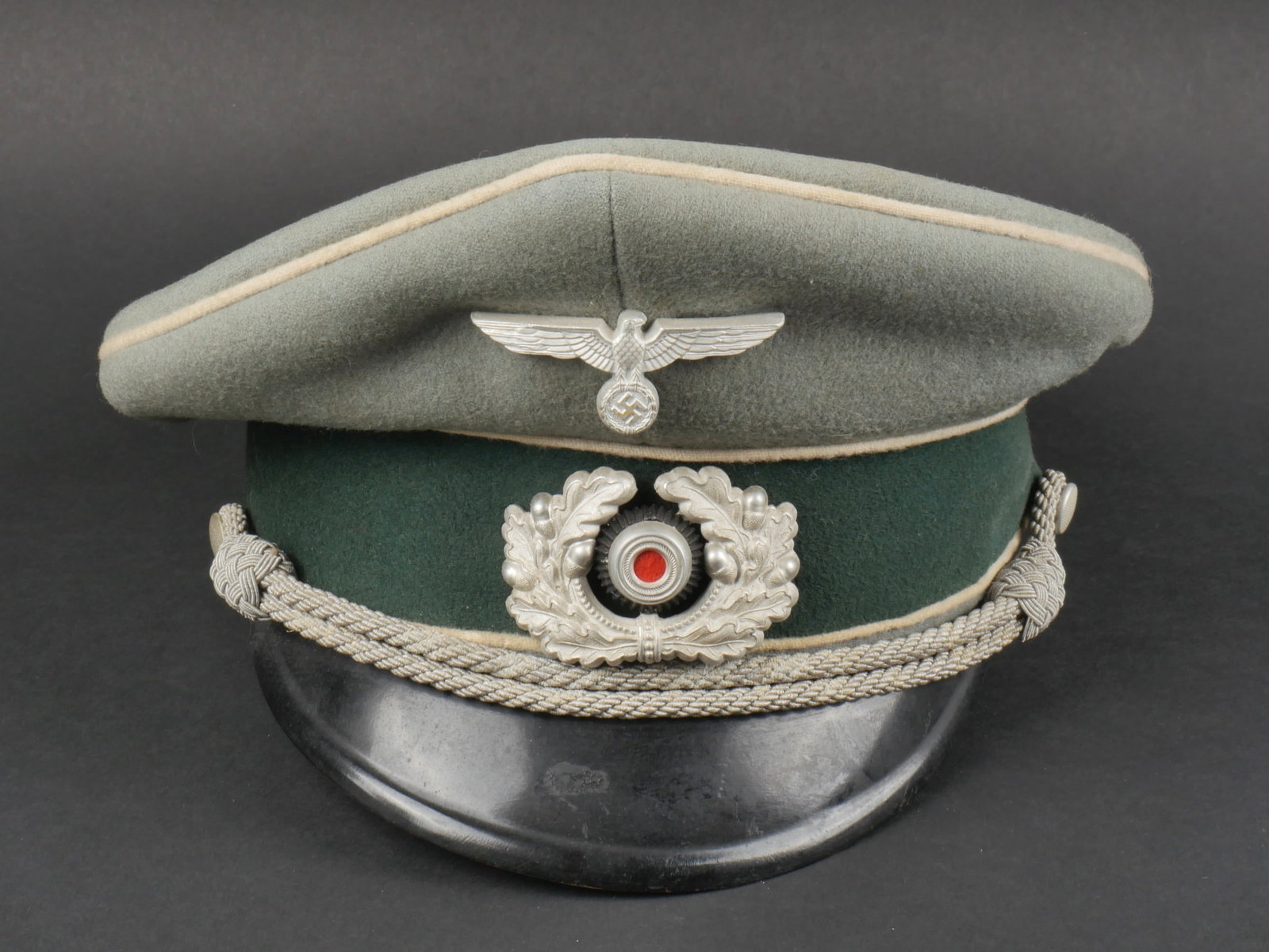 Casquette officier. German officer cap.: Casquette d'officier d'infanterie. En drap Feldgrau, triple lisere blanc de l'infanterie. Bandeau en velours vert. Fausse jugulaire d'officier presente. Insignes metalliques, les insignes n'ont pas et