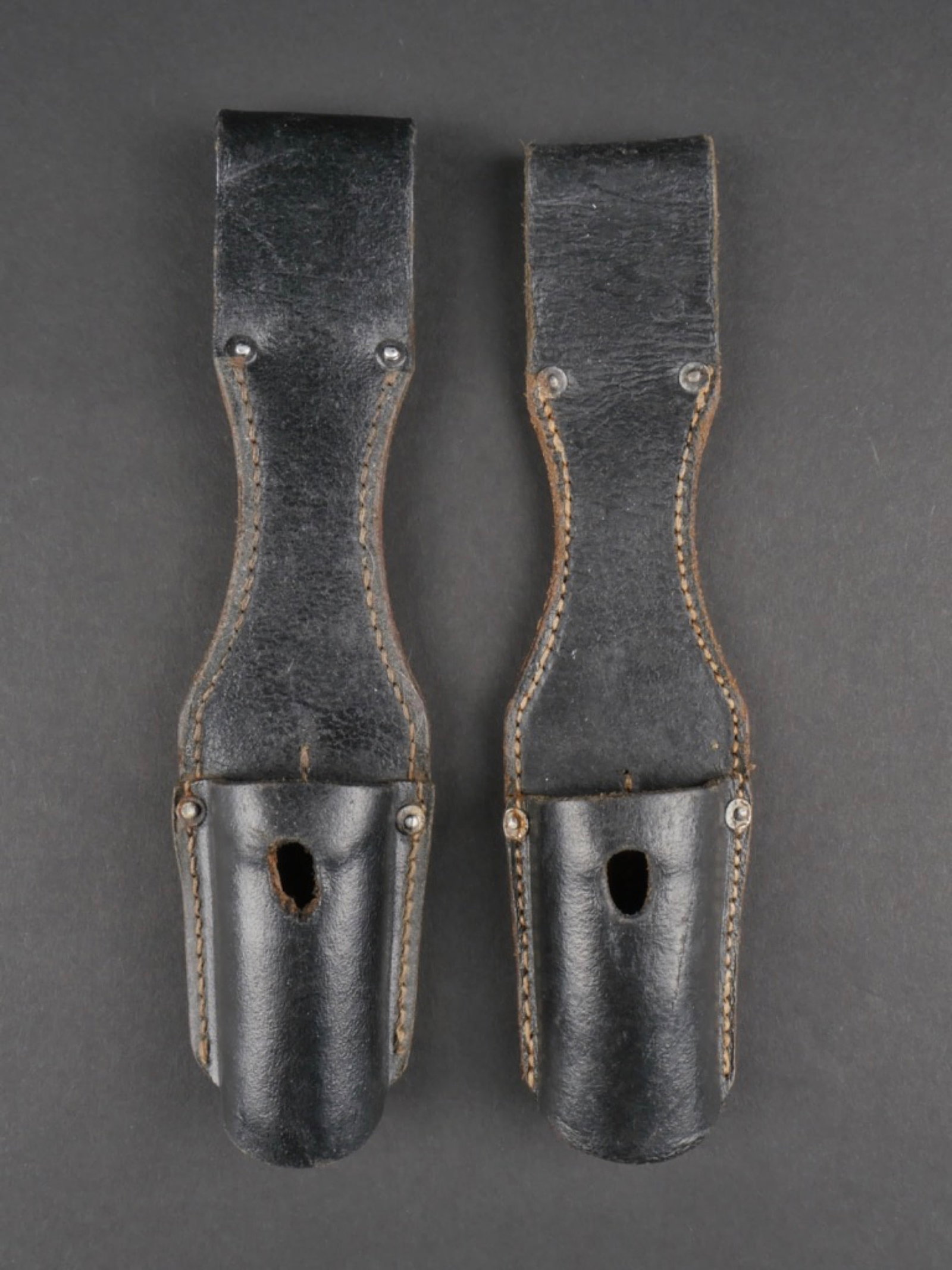 Goussets de baionnette. Bayonet gussets.: Ensemble de deux goussets de baionnette allemande. Comprenant un gousset en cuir noir, modele sans attache , cuir souple, sans marquages visible. Un gousset en cuir noir, modele sans attache, cuir sou