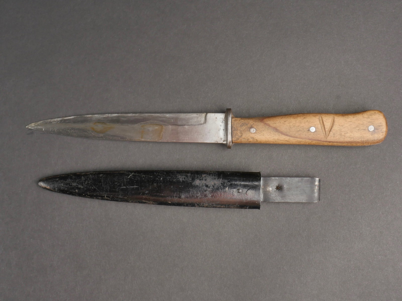 Couteau de botte. Knife boots.: Couteau de botte. Plaquettes en bois, maintenues par trois rivets. Personnalisation par la gravure des lettres V et M. Belle lame huile. Sans marquages visibles, partiellement affotee. Fourreau en met