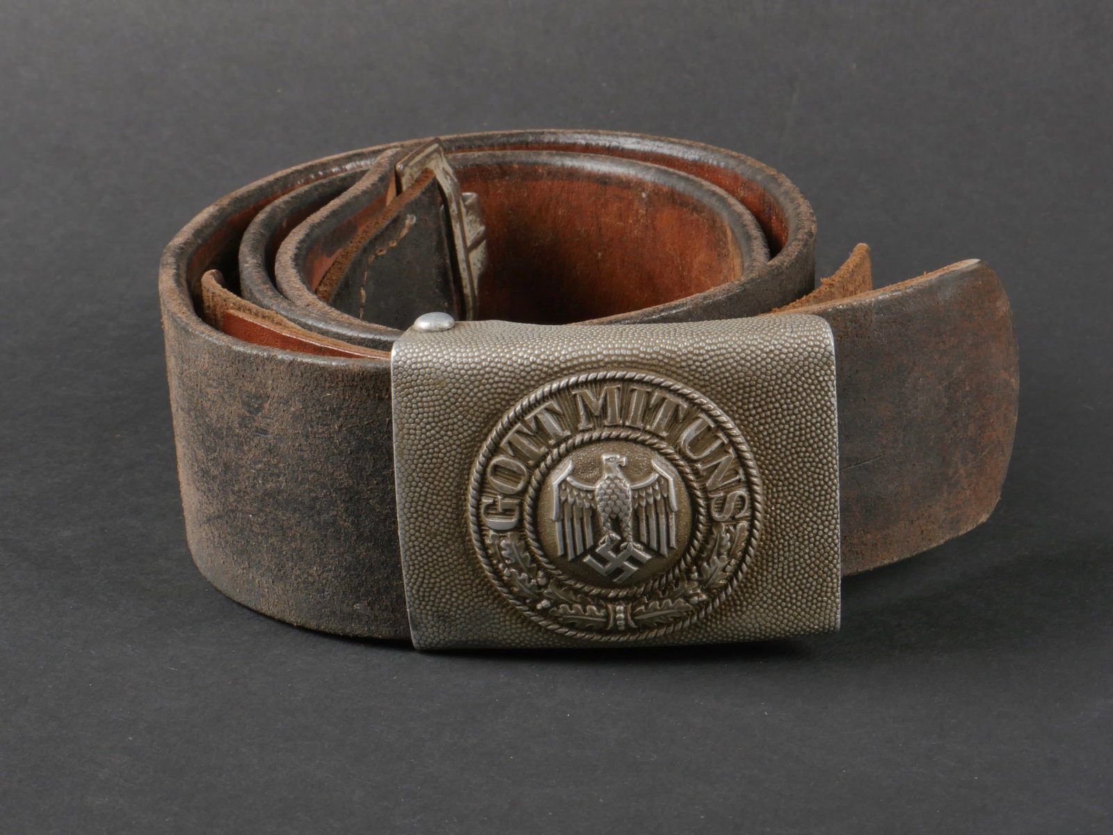 Ceinturon Heer. Heer belt.: Ceinturon de la Heer. Ceinturon en cuir noir, la patte de reglage est montee d'origine, deux rangs de reglage ont ete perces apres la patte de reglage. Bouclerie en metal, sans marquages visibles. Tai