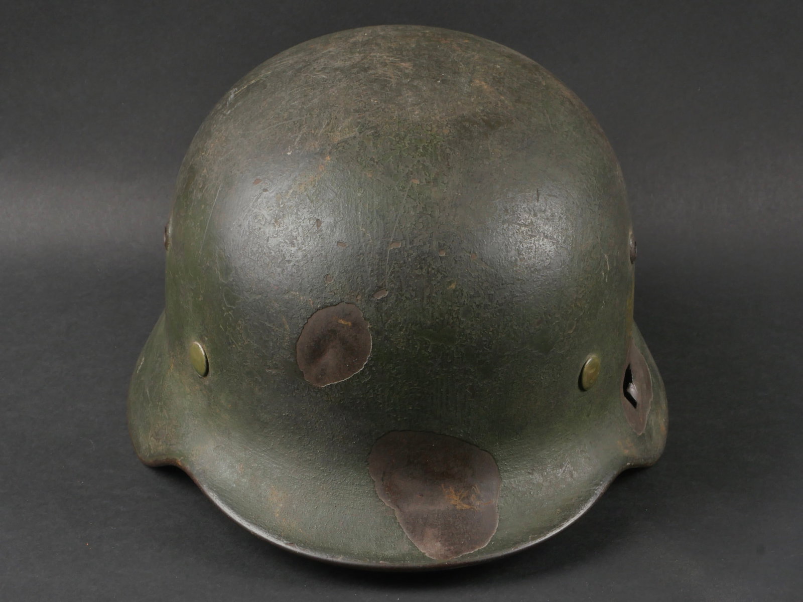 Casque allemand. German helmet.: Casque allemand. Coque de casque M35. Fabrication Q64. Numero de lot 465. Peinture de reconditionnement appliquee au pinceau et recouvrant les couleurs nationales. L'exterieur a ensuite recu une fine 
