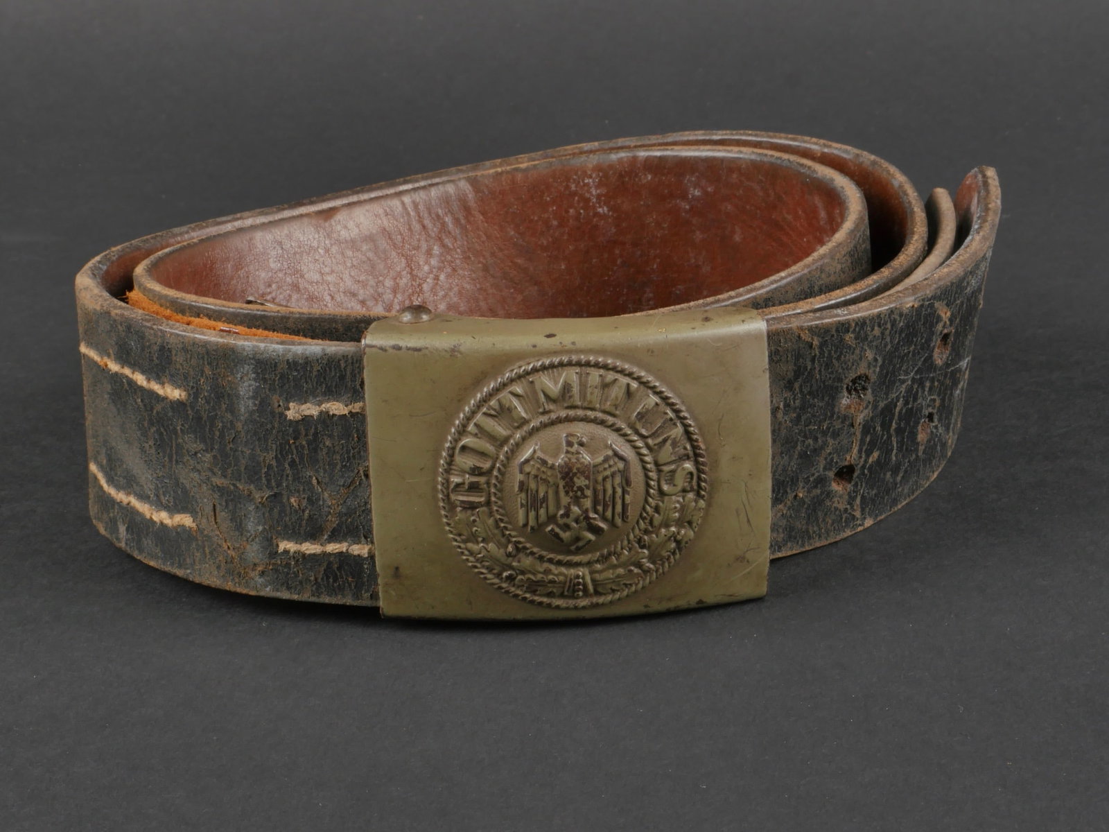 Ceinturon Heer. Heer belt.: Ceinturon de la Heer. Ceinturon en cuir noir, visiblement raccourci. La patte de reglage est presente, mais egalement raccourcie. Sans marquages visibles. Bouclerie en metal. Boucle de ceinturon en me