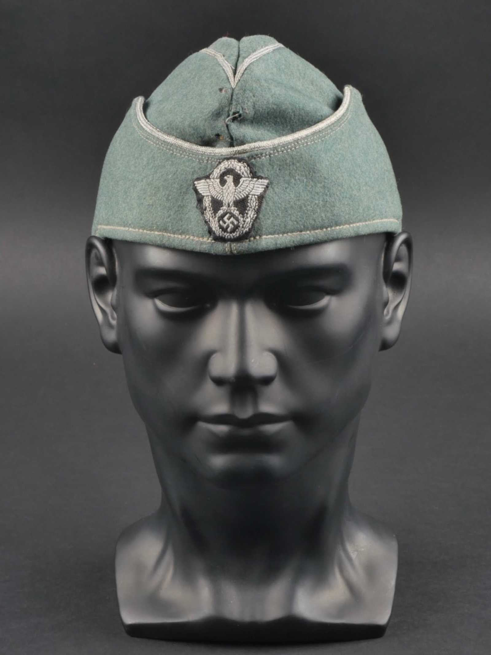 Calot officier Polizei. Polizei officer cap.: calot officier Polizei. En drap gris/vert. Lisere argent faisant le tour de la coiffure. Insigne polizei d'officier, modele Bevo monte main. Interieur double en tissu coton marron. Demi bandeau de sud