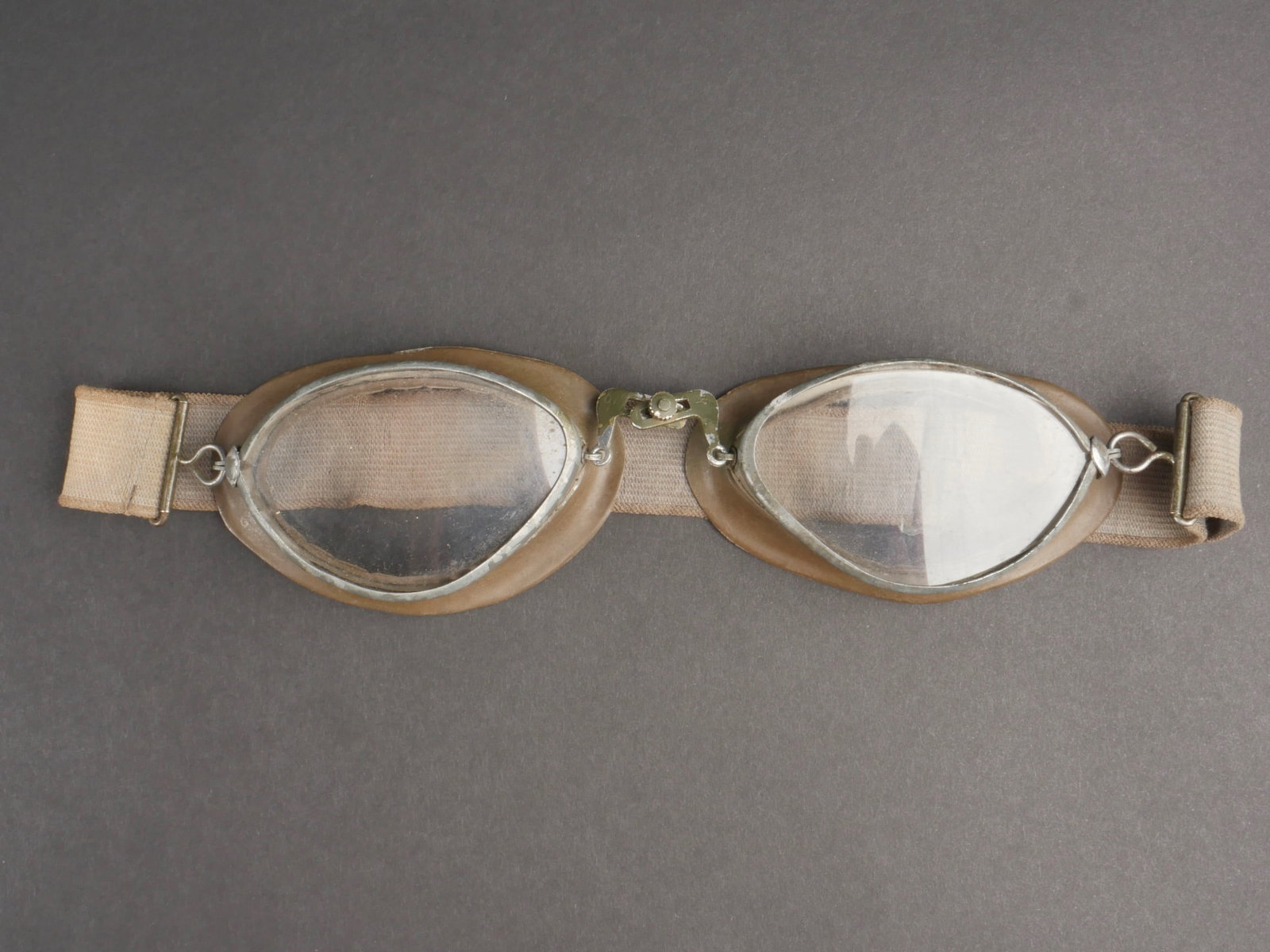 Lunette de motocycliste. Motorcycle goggles.: Lunette de motocycliste allemand. Armature en metal, peinture Feldgrau a 40%. Doublure en caoutchouc kaki. Les verres sont blancs. Elastique present et relativement souple. Marquages Ow 43 A noter une