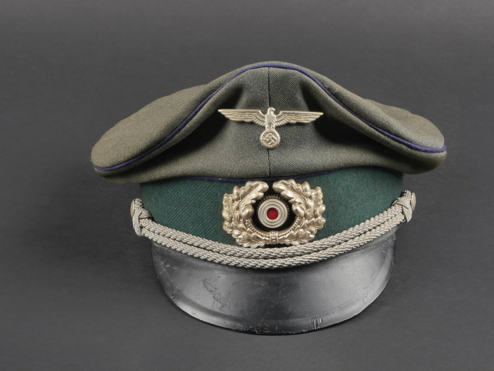 Casquette officier medecin. Medical officer's cap.: Casquette d'officier medecin. En gabardine Feldgrau, triple lisere bleu des services de sante. Insignes metalliques. Les insignes n'ont pas ete demontes afin de verifier les attaches. Fausse jugulaire