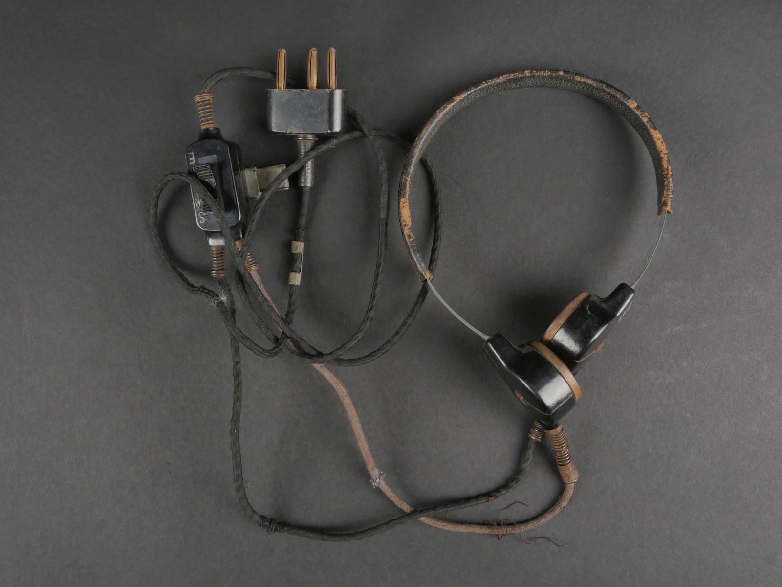Laryngophone panzer. Panzer laryngophone.: Laryngophone Panzer. Armature en metal, recouvert de cuir noir, fortement use. Les laryngophones sont en bakelite. Cable et prise presents. Boitier SpSc complet en bakelite, pince fonctionnelle. Cable