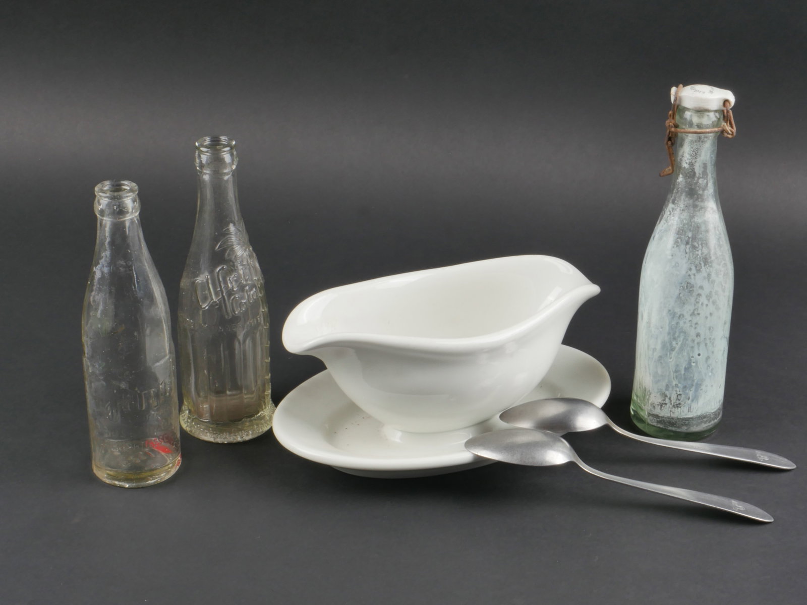 Vaisselle allemande. German tableware.: Vaisselle allemande. Comprenant une sauciere en porcelaine blanche. Bel aigle de la Luftwaffe, marquages FL UW 1941 Bohemia. Longueur 26 cm. Deux cuilleres en metal, disposants d'insignes de la Heer, 