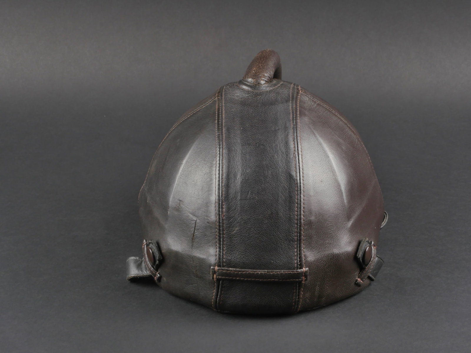 Casque SSK 90. SSK 90 helmet.: Casque SSK 90. Casque constitue de plaques de metal, recouvert d'un epais cuir marron. Bourrelet de protection en cuir marron, sur le haut de la coque. Interieur rembourre et recouvert d'un tissu marr