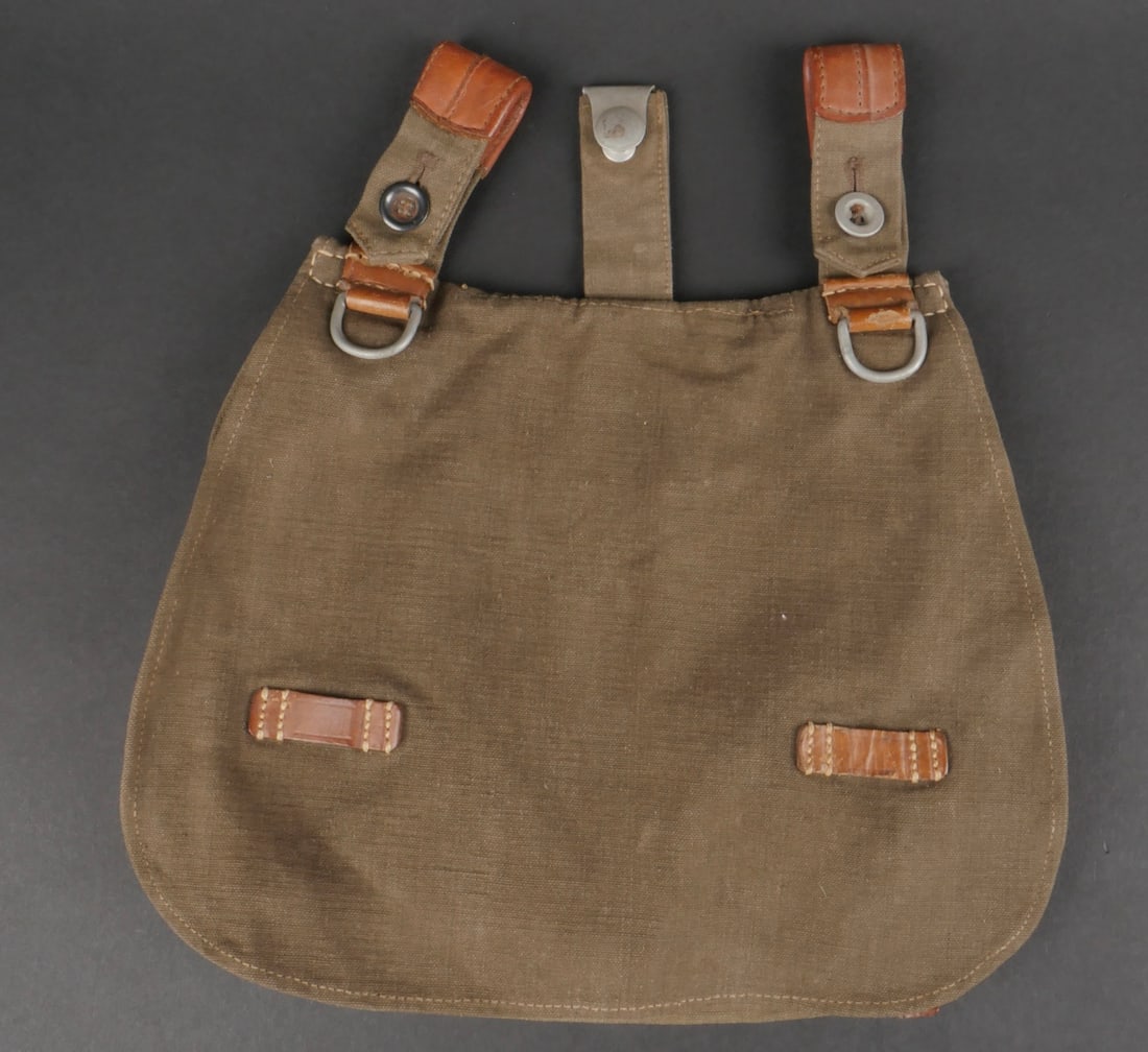 Sac a pain LW. Luftwaffe bread bag.: Sac a pain LW. En tissu gris bleu et cuir marron. Marquages 7 38 RADRAF Heinrich Sattel Munchen 638. A noter une certaine usure et patine de la piece, ainsi que quelques taches. Etat II+. LW bread bag