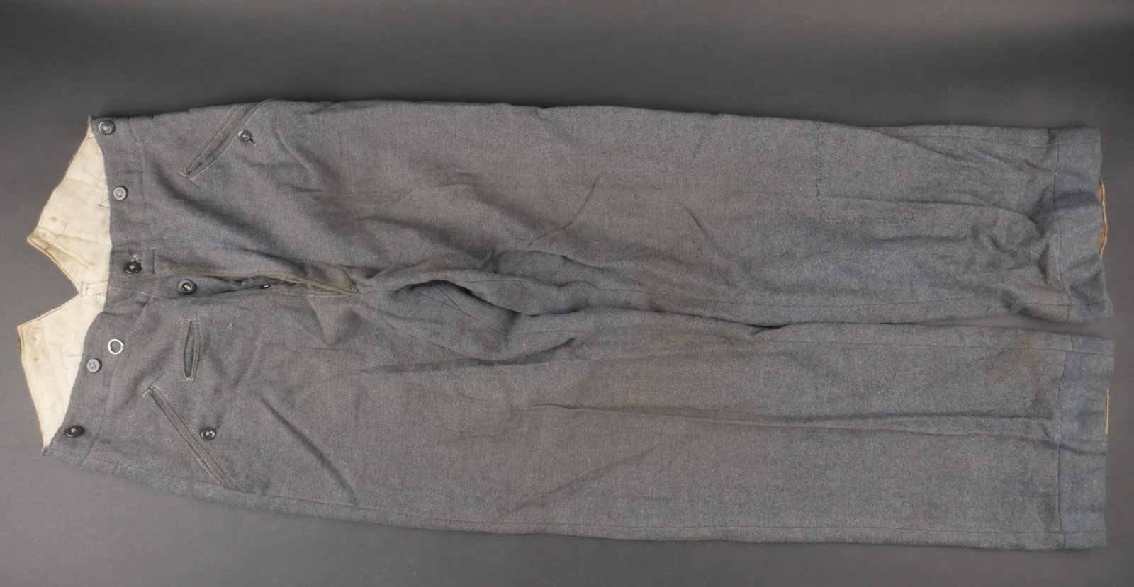 Pantalon LW. Luftwaffe trousers.: Pantalon de la Luftwaffe. Modele M-40. En drap gris/bleu. Tous les boutons sont presents. Interieur double en tissu coton blanc. Marquages RBNr 0/0911/0018. Indications de taille 80 92 114 98. A noter