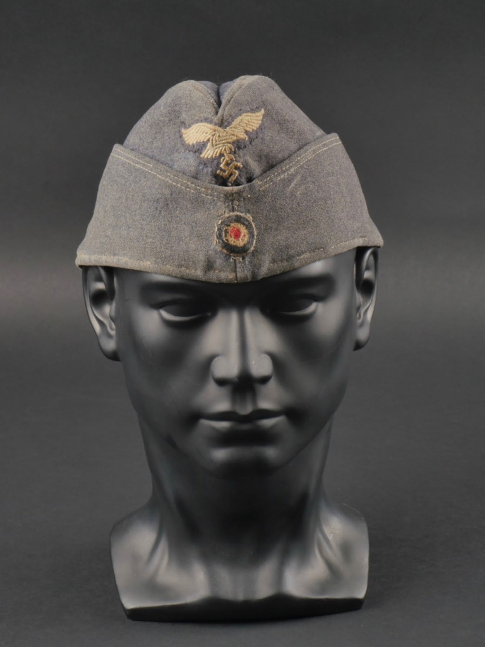calot LW. Luftwaffe cap.: calot de la Luftwaffe. Modele troupe. En drap gris/bleu. Aigle de la Luftwaffe brode, et monte main. cocarde fortement abimee et montee main. Interieur double en tissu coton gris, les marquages sont i