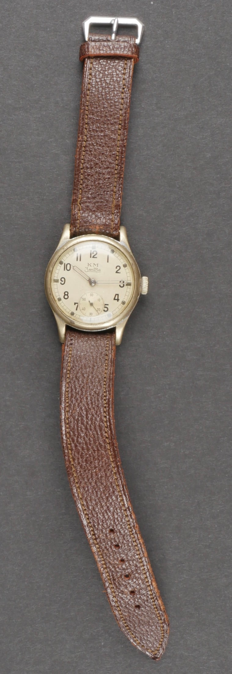 Montre Kriegsmarine. Kriegsmarine watch.: Montre Kriegsmarine. cadran en metal, chiffres arabes. Les aiguilles sont presentes. Marquages KM Zentra. Non fonctionnelle. Bracelet en cuir marron, fermoir en metal, boucle a un seul ardillon. Numer