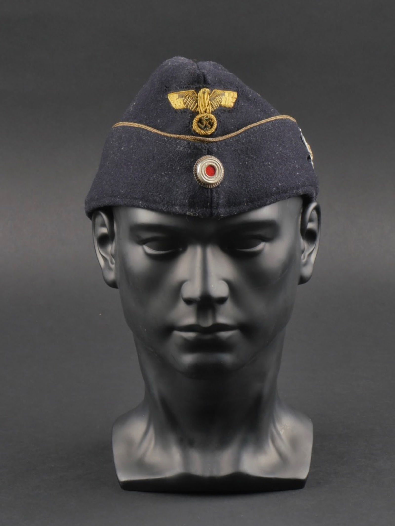 calot Kriegsmarine. Kriegsmarine cap.: calot d'officier Kriegsmarine. En drap noir. Lisere or faisant le tour de la coiffure. Aigle brode or, monte main. cocardes metalliques. Edelweiss cousu sur le cote gauche du calot. Interieur double e