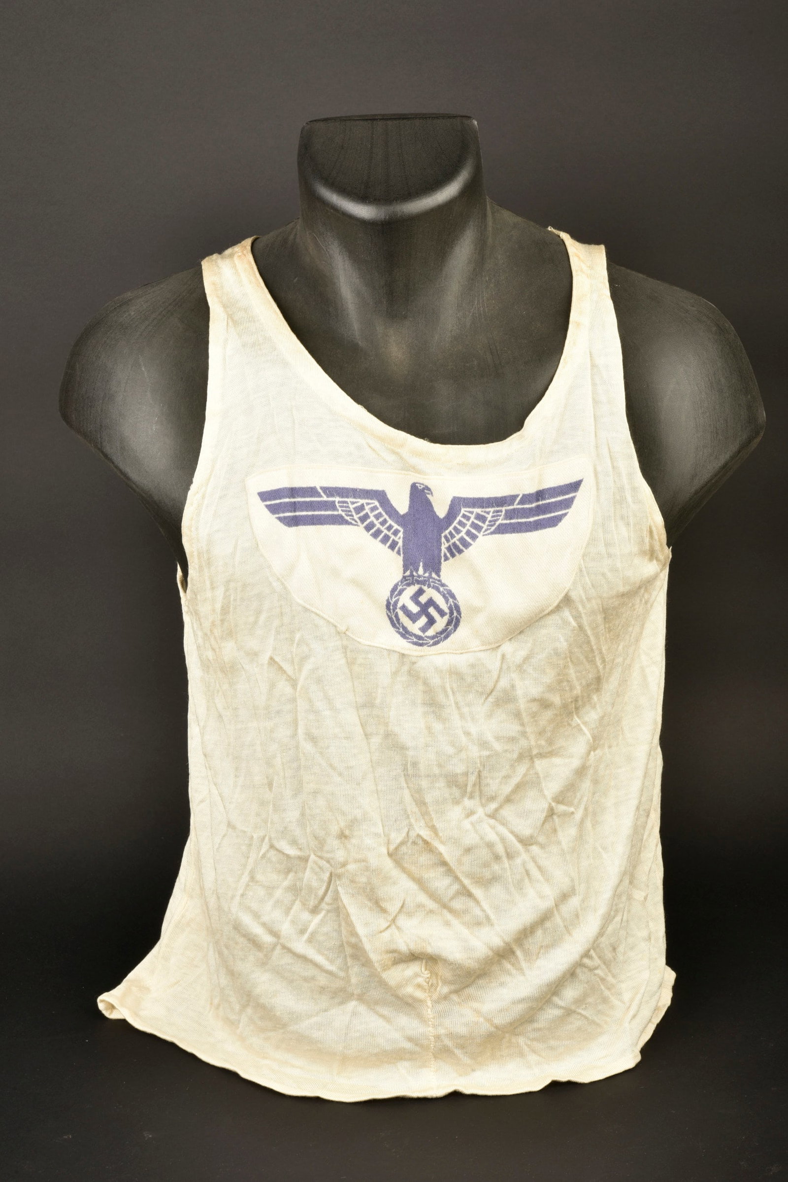 Maillot de sport Kriegsmarine. Kriegsmarine sports shirt.: Maillot de sport Kriegsmarine. Tee-shirt en soyeux blanc, sans manche, type debardeur. Insigne en tissu coton bleu brode, monte machine. Sans marquages visibles. A noter une certaine usure et patine d