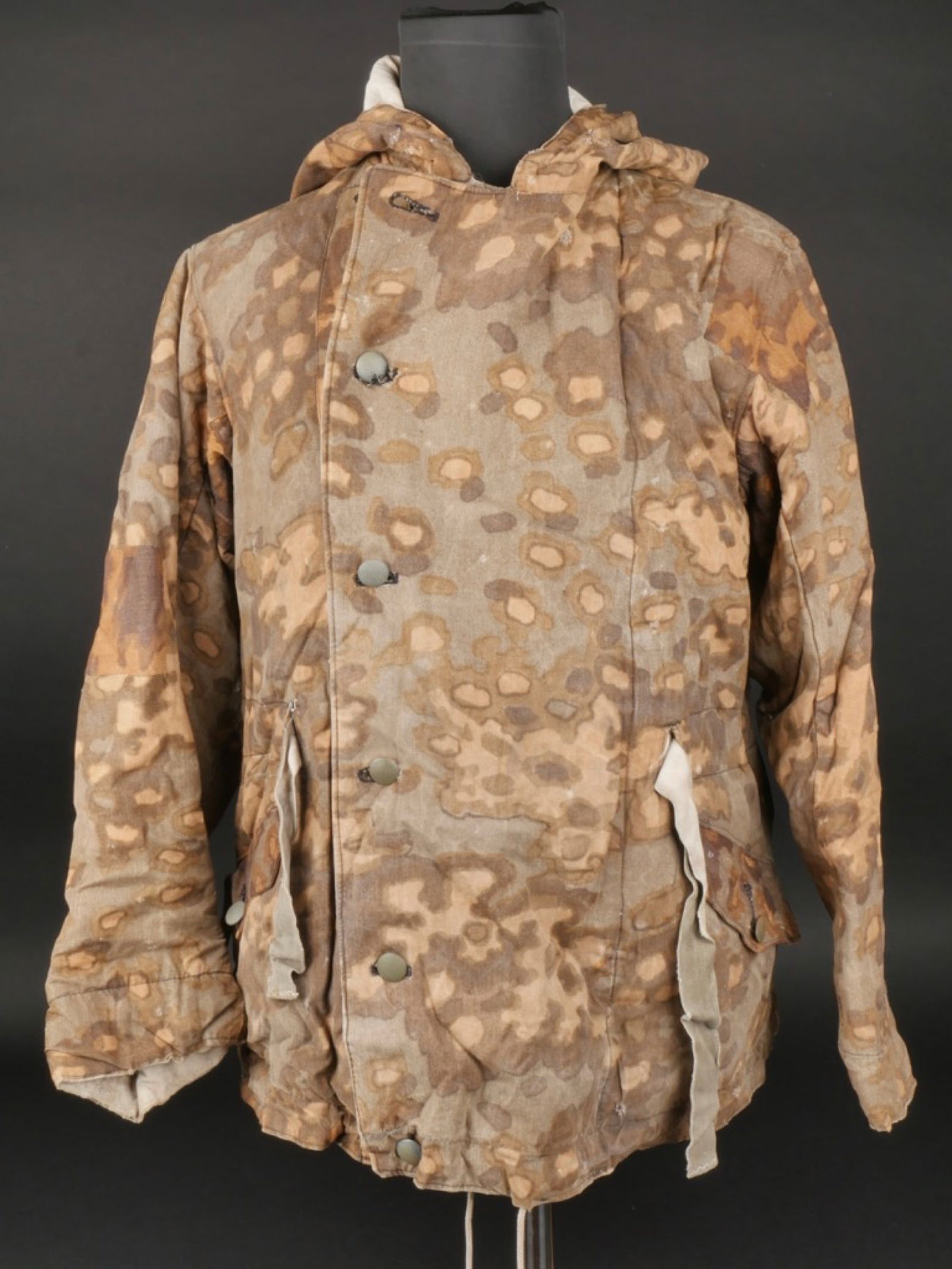 Parka reversible SS. SS reversible parka.: Parka reversible de la Waffen SS. En tissu camoufle printemps, reversible blanc. Les couleurs du cote automne sont passees par le soleil. Tous les boutons sont presents. Le cordon de serrage a la tail