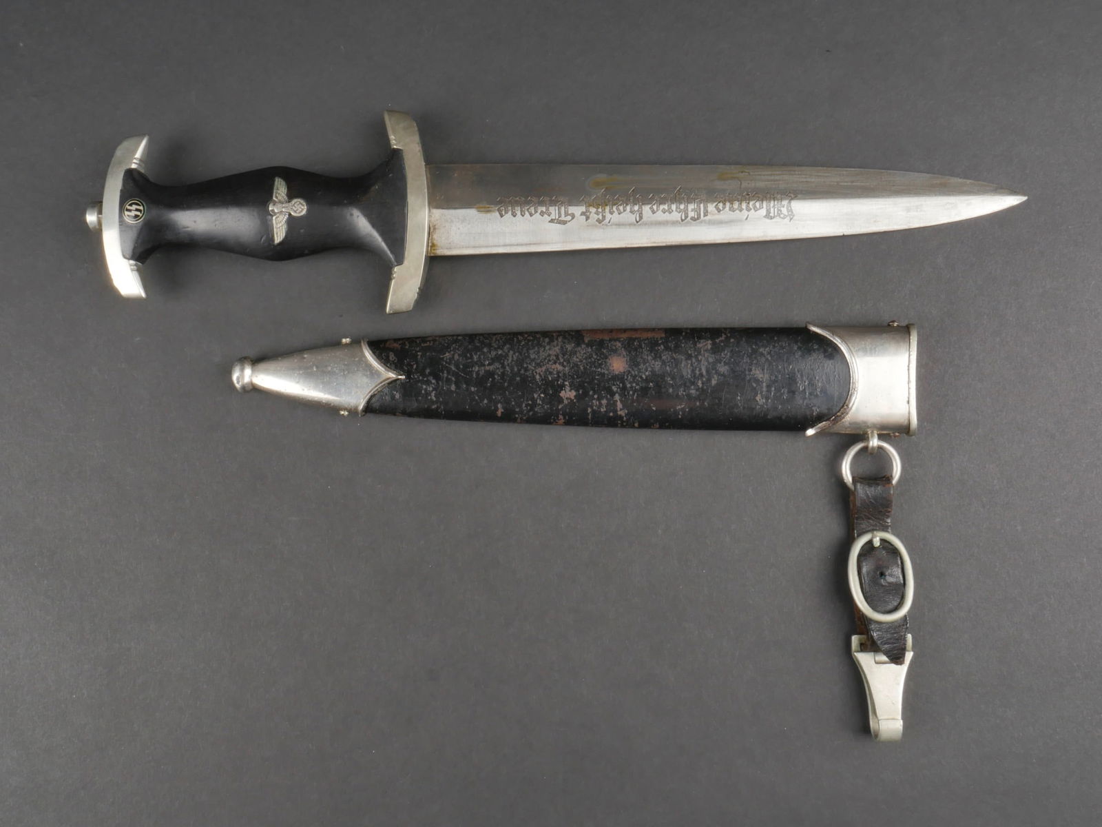 Dague de service SS. Waffen SS Dagger.: Dague de service SS. Modele 1933. Garniture en metal, couleur argent. Poignee en bois noir, portant l'aigle allemand et l'insigne de la SS. L'aigle ressort partiellement de la poignee. Lame fortement