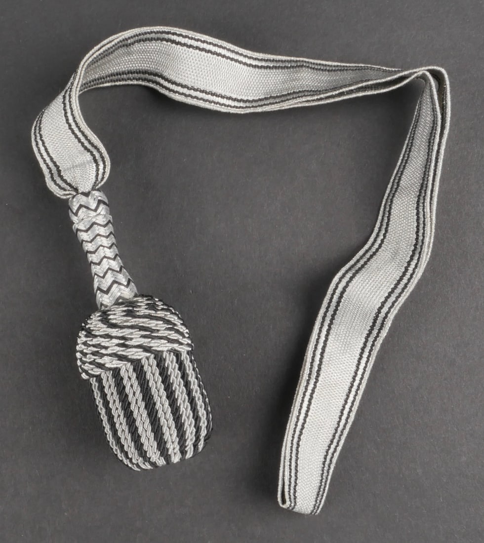 Dragonne de dague SS. SS dagger strap.: Dragonne de dague SS. Modele pour l'Allgemeine SS. Galon argent surpique de fils noir. Gland tresse argent et noir. Fond du gland de couleur argent. Longueur totale 40 cm. A noter une certaine usure e