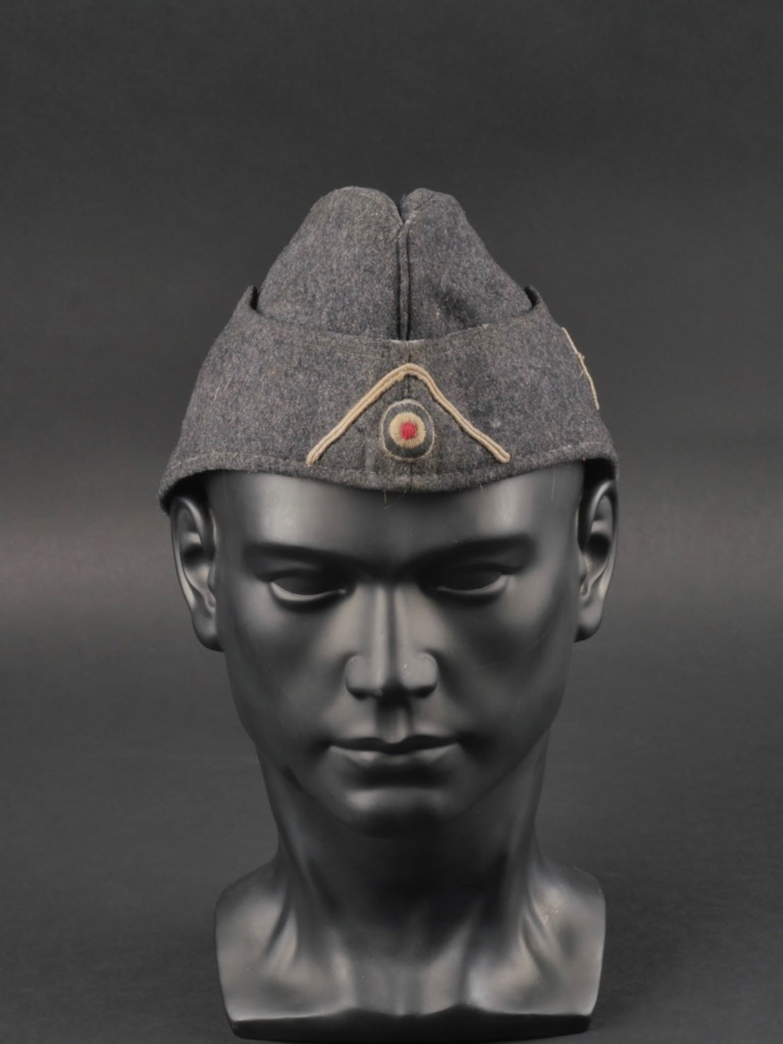 calot DRK. German DRK cap.: calot DRK. En drap de laine gris fonce. cocarde brodee monte main. Soutache grise. Insigne DRK monte main sur le cote gauche du calot. Interieur double en tissu coton gris, taille 57. A noter une cert