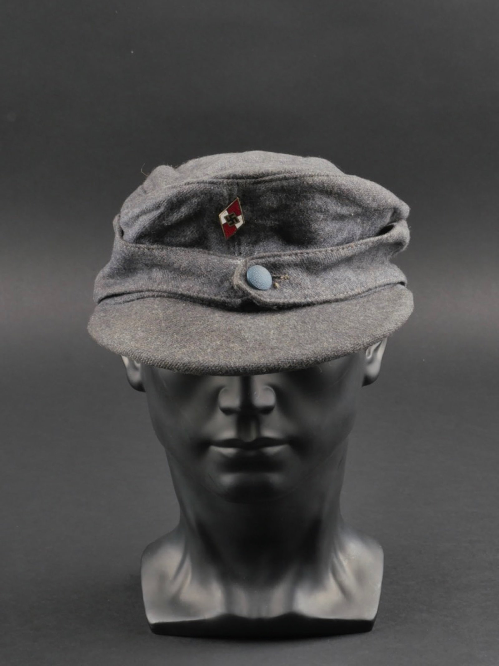 casquette HJ. Hitlerjugend cap.: casquette Hitlerjugend. En drap gris/bleu. Un bouton grenele bleu fermant les rabats. Insigne metallique emaille Hitlerjugend. L'insigne n'a pas ete demonte afin de verifier l'attache et les marquages