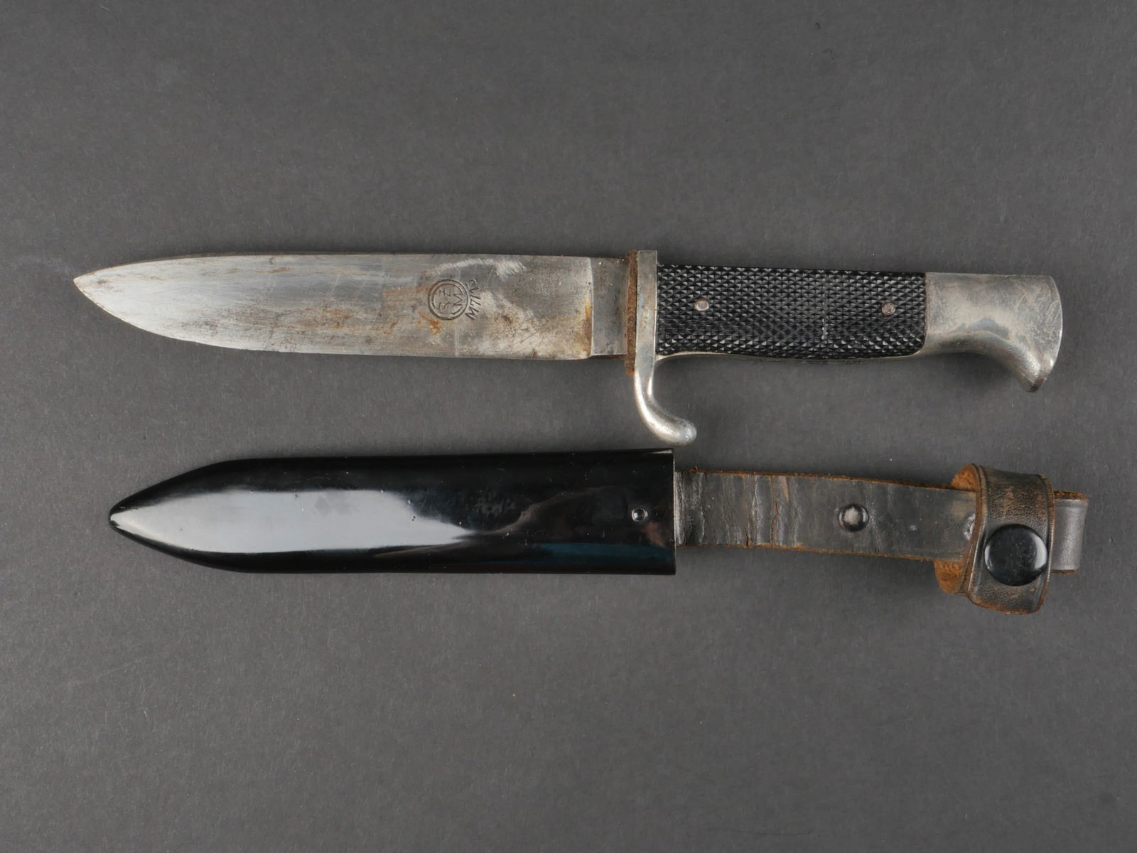 couteau de marche HJ. Hitlerjugend dagger.: couteau de marche de la Hitlerjugend. Garniture en metal nickele fortement frotte. Plaquettes en bakelite. Une plaquette est cassee et recollee. Insigne HJ emaille, recolle au niveau de la poignee. La