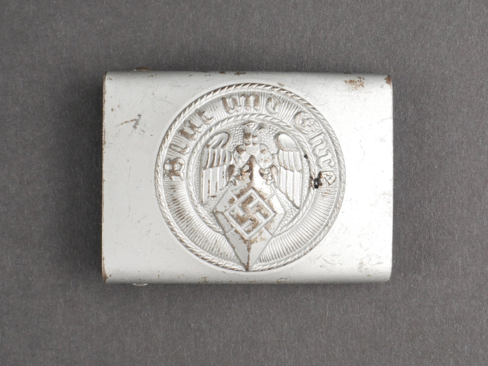 Boucle de ceinturon HJ. Hitlerjugend belt buckle.: Boucle de ceinturon Hitlerjugend. En metal, couleur argent a 70%. Sans marquages visibles. Boucle a deux ardillons complete. Etiquette marquee RZM 482211, code fabricant partiellement illisible. A not