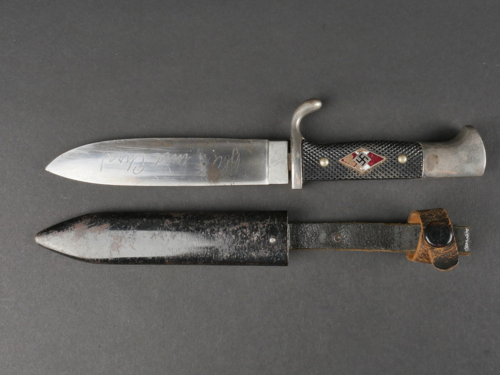 couteau de marche HJ. Hitlerjugend dagger.: couteau de marche de la Hitlerjugend. Garniture en metal nickele, plaquettes en bakelite noire, insigne emaille HJ fortement abime avec des manques, et visiblement recolle. Renfort en cuir manquant au