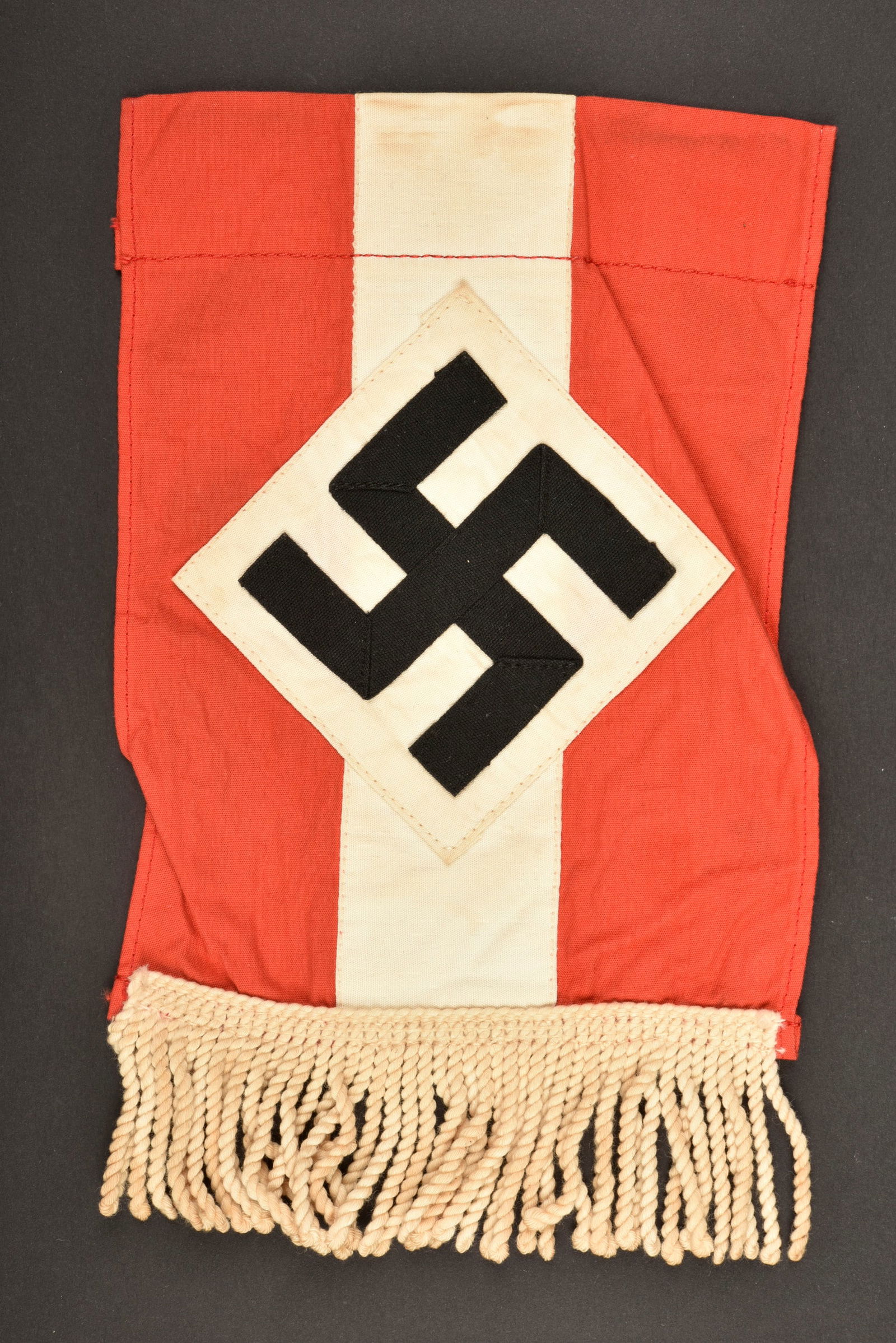 Petit drapeau HJ. Hitlerjugend little flag.: Drapeau de table Hitlerjugend. En tissu coton rouge et blanc. Insigne national tisse et rapporte, fabrication en plusieurs parties. Franges blanches presentes. Sans marquages visibles. Dimensions avec