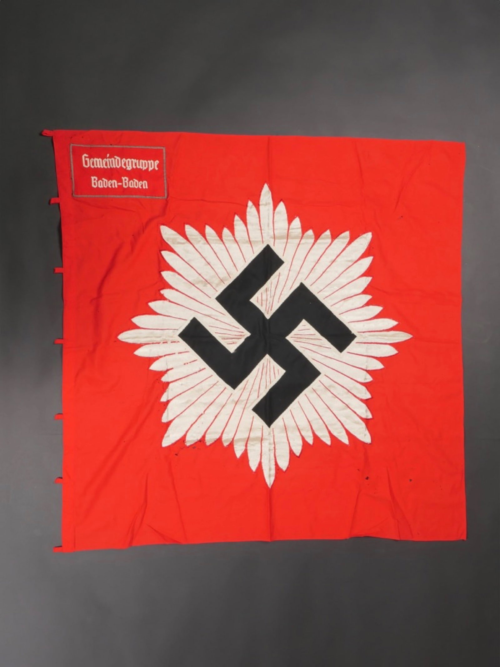 Drapeau de la Luftschutz. Luftschutz flag.: Drapeau de la Luftschutz. En tissus coton rouge. Les lanieres de fixations au mat ont ete coupees et reparees. Insigne de la Luftschutz brode et rapporte. Biface en ce qui concerne l'encart mais pas p