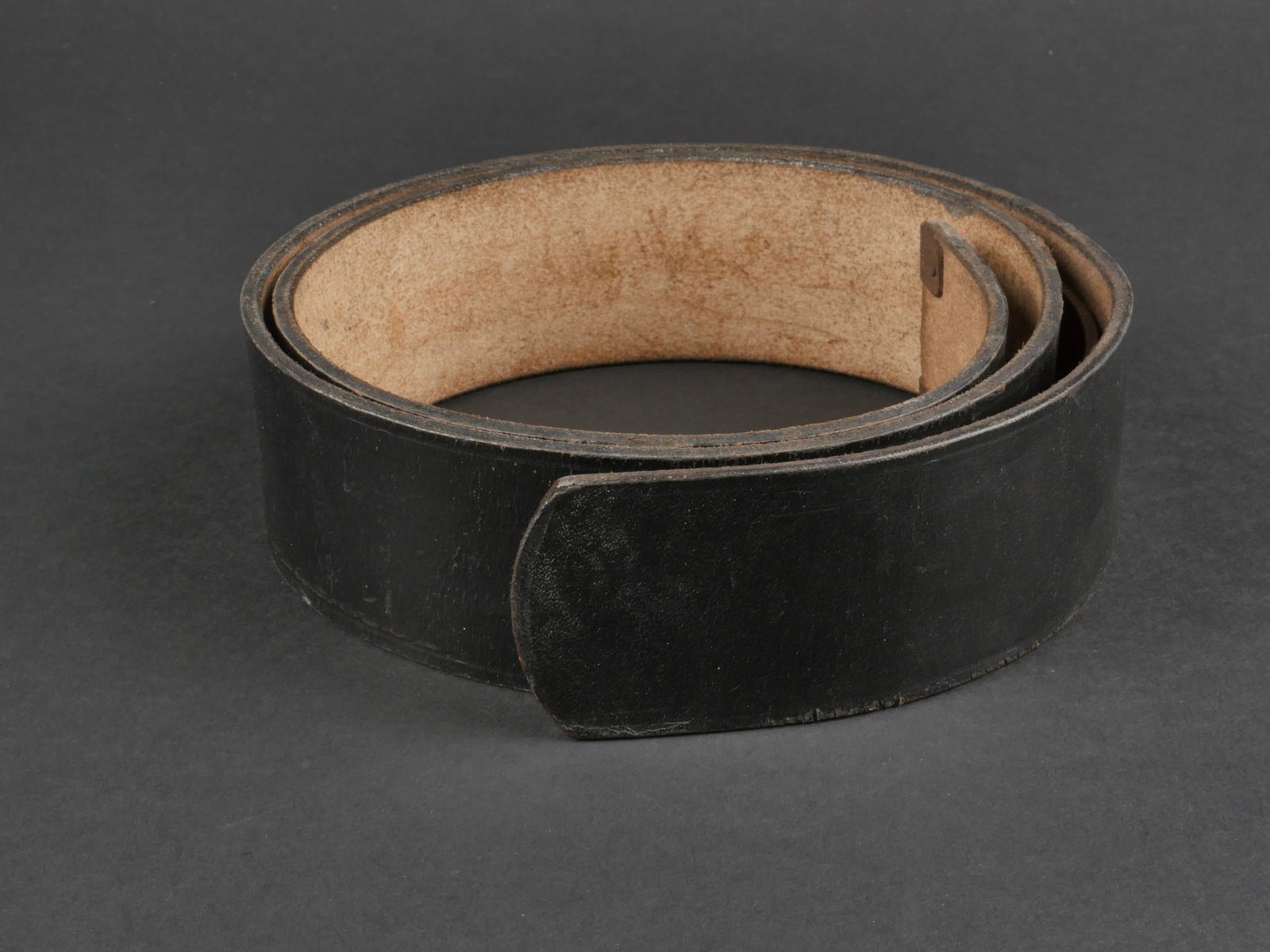 ceinturon AHS. AHS belt.: ceinturon Adolf Hitler Schule. En cuir noir. Garnitures metalliques. Taille 90. La patte de reglage en cuir est presente. Marquages RZM L2/954/40 BMD 41. Beau marquage AHS estampille dans le cuir. A n