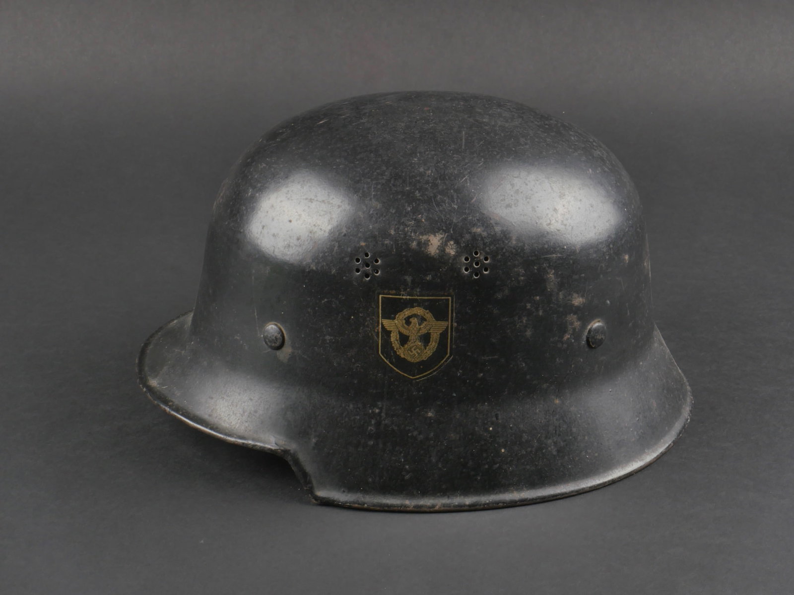 casque de pompier. German firefighter helmet.: casque de pompier allemand. coque de casque en metal. Peinture noire a 80%. Insigne a 90%, couleurs nationales a 90%. Nuquiere en cuir manquante. coiffe complete en cuir fauve avec son cordon de serra