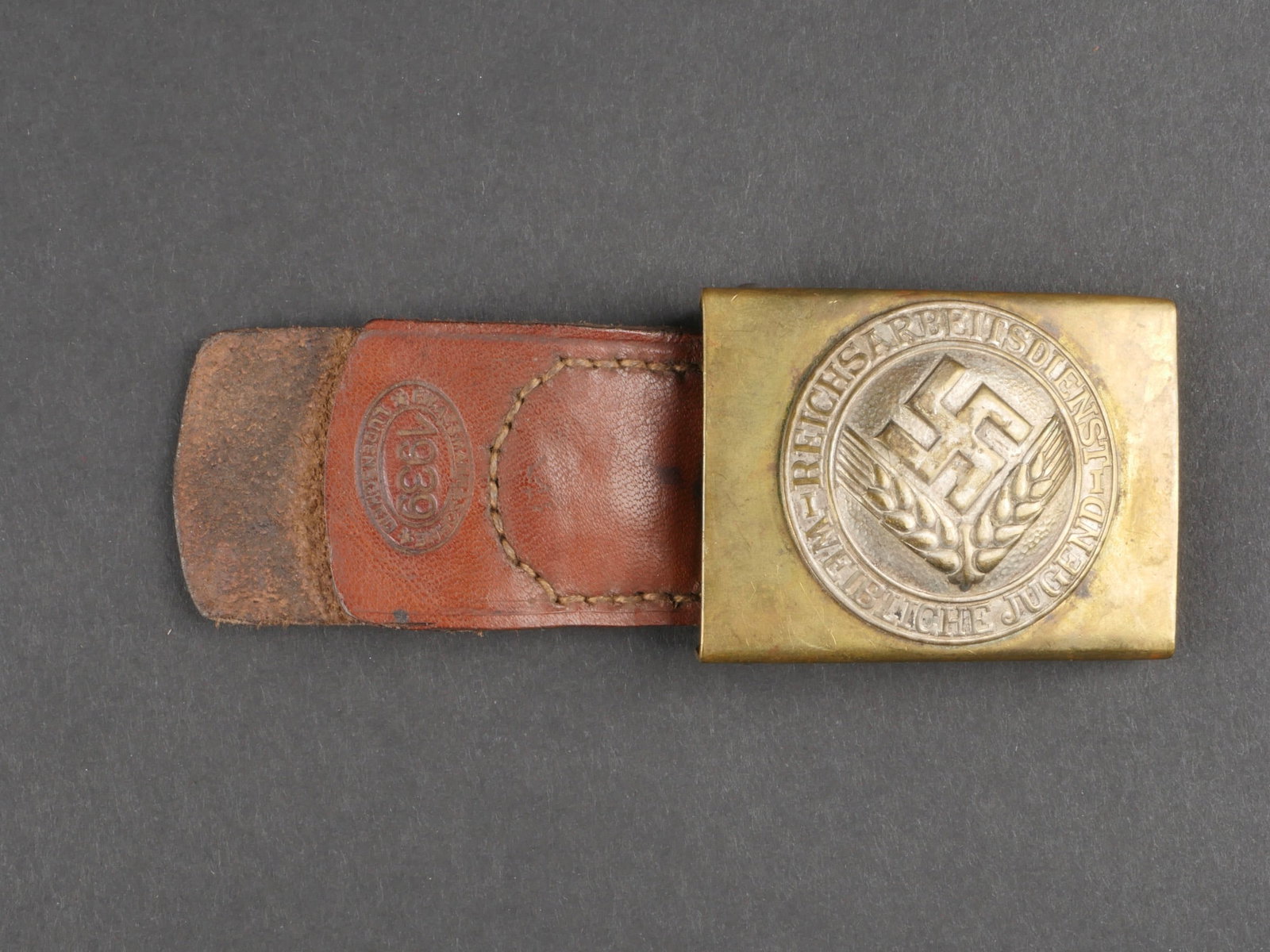 Boucle de ceinturon RAD. German RAD belt buckle.: Boucle de ceinturon RAD. En laiton, insigne Reichsabeitsdienst Weibliche Jugend rapporte. Patte en cuir complete, marquee Assmann 1939. Boucle a deux ardillons complete. A noter une certaine usure et 