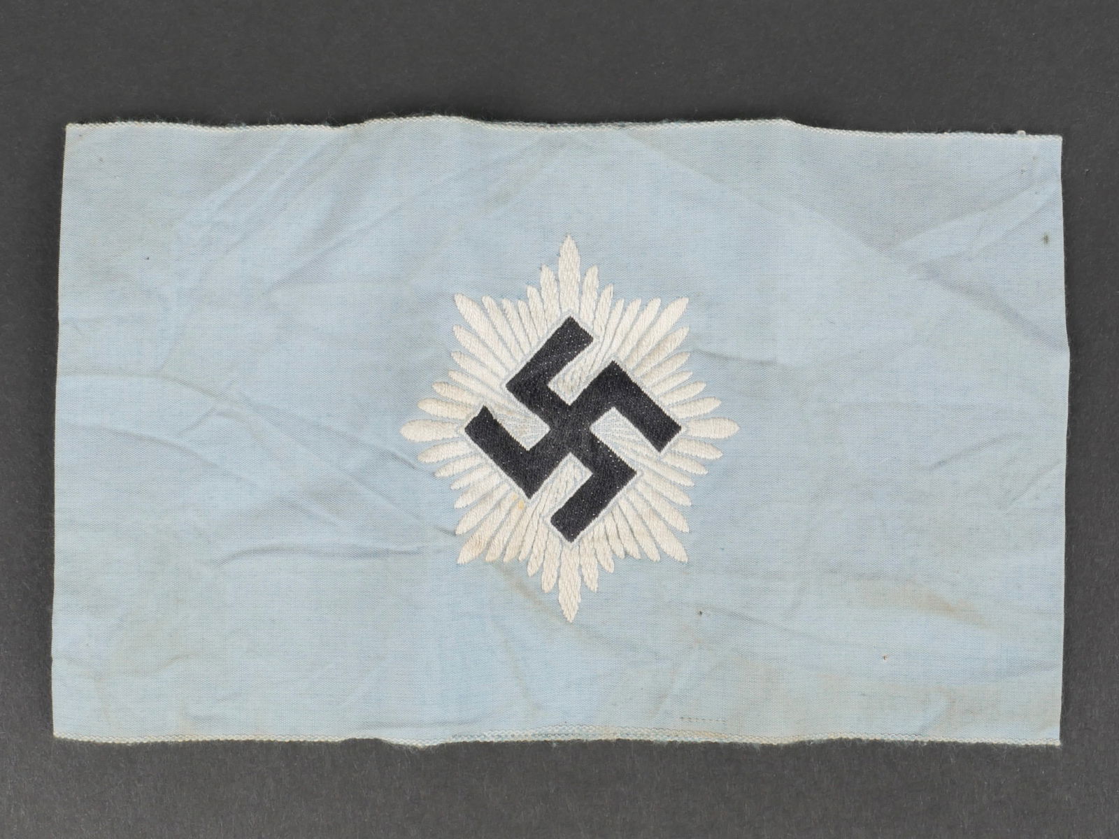 Brassard RLB. German RLB armband.: Brassard RLB. En tissu coton bleu ciel. Insigne brode. Marquages Ges Gesch H&F. Second modele. A noter une certaine usure et patine de la piece, ainsi que des taches. Etat II+. RLB armband. Light blue