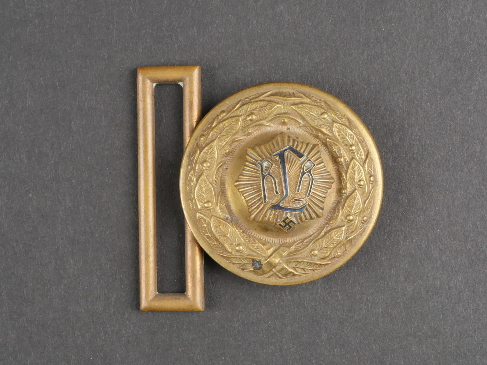 Boucle RLB. German RLB belt buckle.: Boucle de ceinturon d'officier RLB. En laiton dore. Insigne RLB en relief, tres bombe. Fabrication en deux parties. Incomplete. Marquages DRGM. A noter une certaine usure et patine de la piece. Etat I