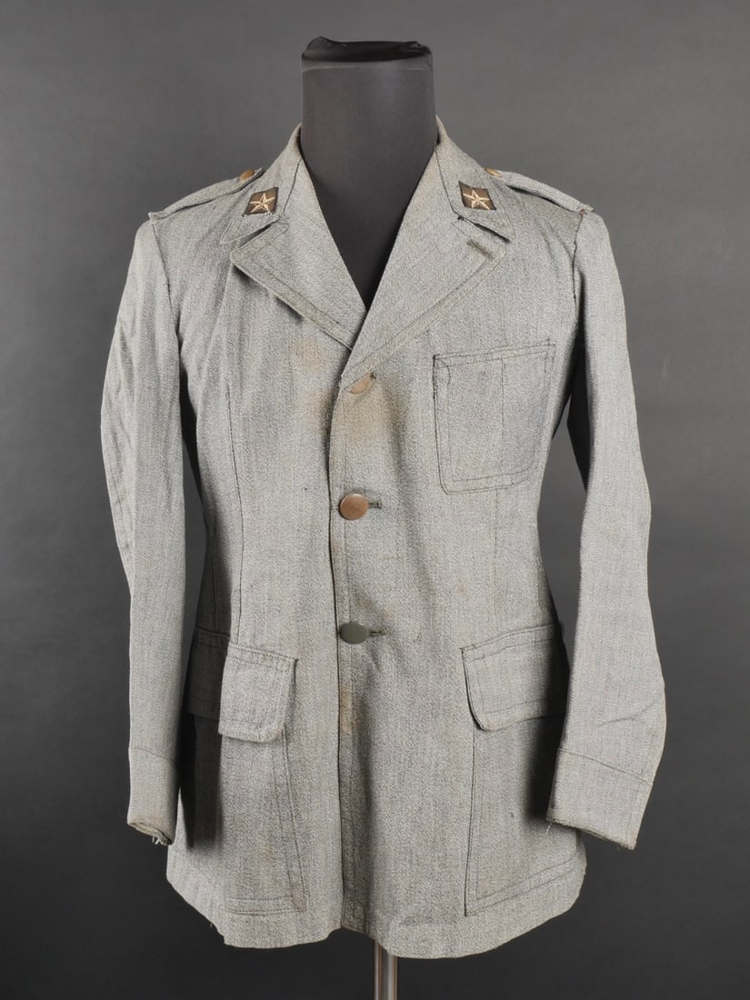 Vareuse troupe de l’armee Royale. Royal Army troop jacket.: Vareuse troupe de l’armee Royale. En toile grise avec ses Mostrine tisse au col, complet de tous ses boutons, pattes d’epaule cousues. Etat I-. Royal Army troop jacket. In gray canvas with Mostrin