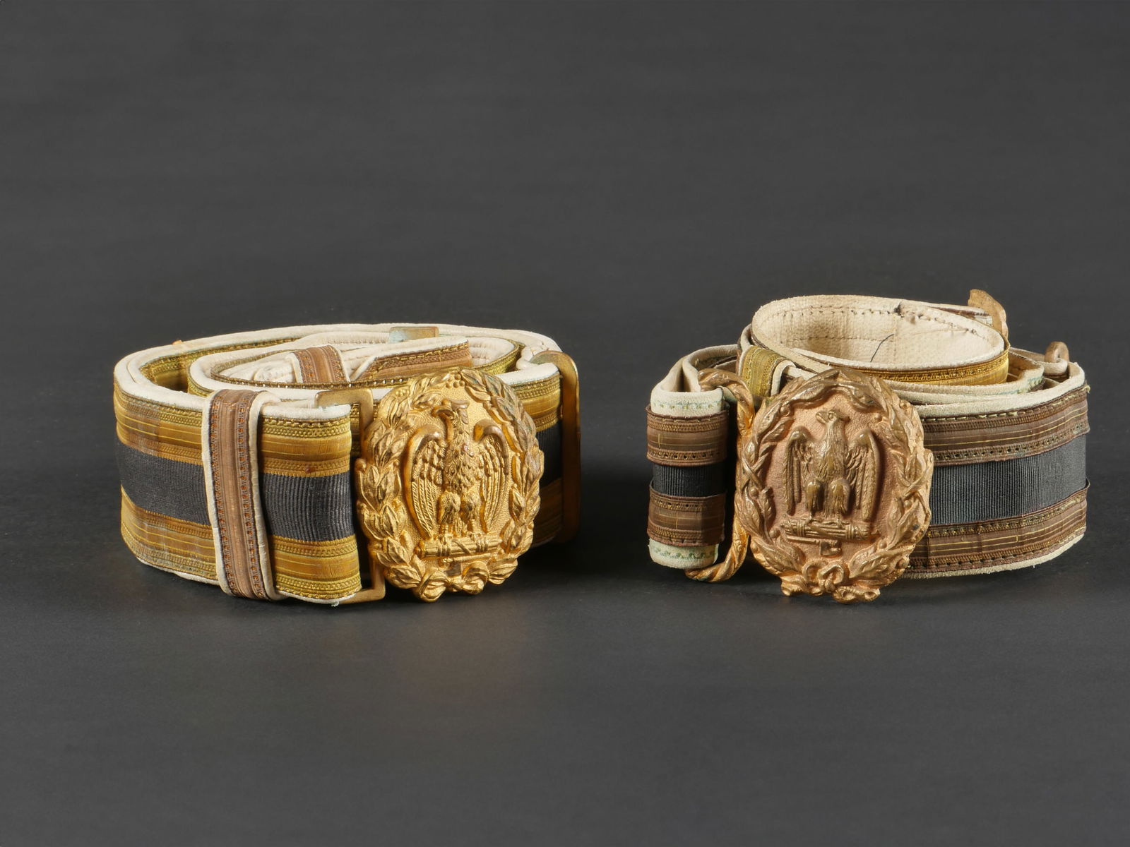 Lot de deux ceinturons d’officier de la MVSN. Set of two MVSN officer s belts.: Lot de deux ceinturons d’officier de la MVSN. Destines a la grande tenue, complet avec leurs plateaux, les deux sont decousus sur la bande exterieur. Etat II-. Set of two MVSN officer s belts. Inten